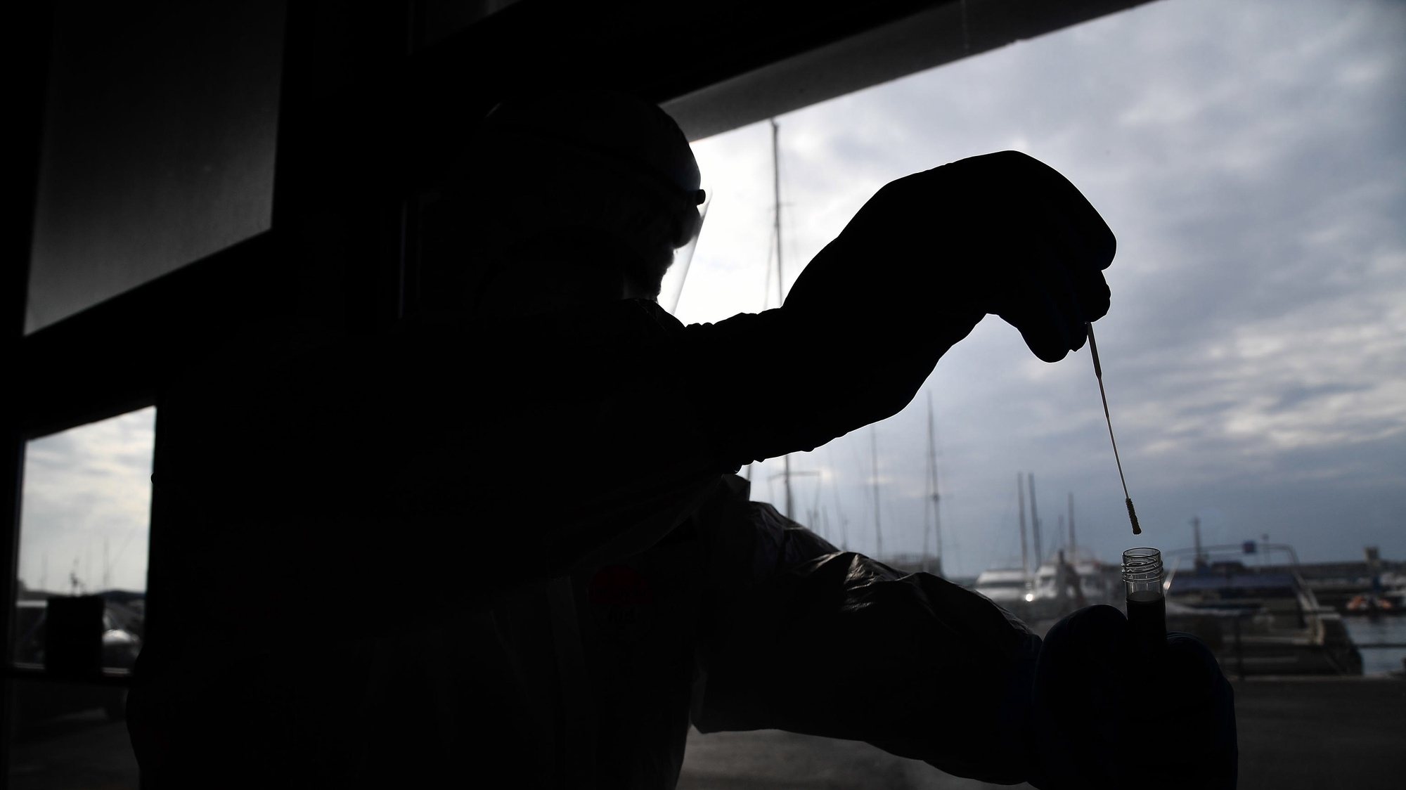 epa08818102 A health worker of the Navy Army collects a nose swab sample for a polymerase chain reaction (PCR) test at the Genoa Fair drive through coronavirus testing facility during the coronavirus disease COVID-19 outbreak, in Genoa, Italy, 13 November 2020.  EPA/LUCA ZENNARO
