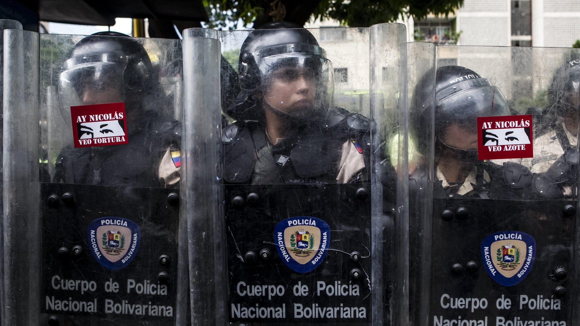 epa04203137 Members of the Policia Nacional Bolivariana have protest stickers reading &#039;Oh Nicolas, I see torture&#039; (L) and &#039;Oh Nicolas, I see whippings&#039; placed on their riot shields during an opposition march in the Las Mercedes area of Caracas, Venezuela, 12 May 2014. Authorities in Venezuela blocked an opposition march as members of the student opposition movement called for new protests asking for detained protestors to be freed. Protests against the government of President Nicolas Maduro, which have been ongoing since 12 February, have left at least 42 people dead and more than 700 injured.  EPA/MIGUEL GUTIERREZ