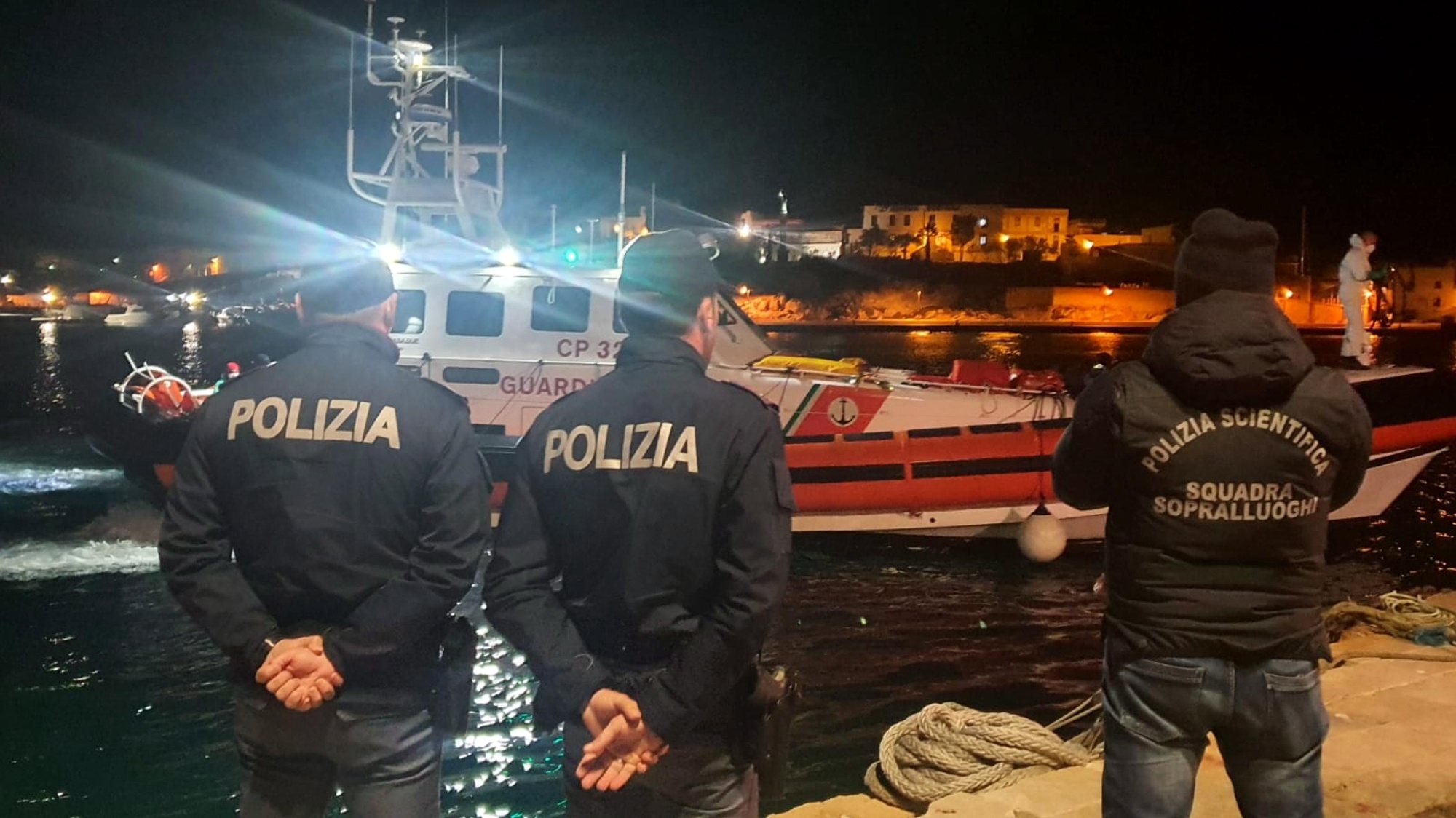 epa10445201 Police officers on the quay of the port wait for the boat containing the bodies of 8 migrants in Lampedusa, Sicily, Italy, 03 February 2023. The soldiers of a Coast Guard patrol boat rescued the boat, with dozens of North Africans on board and also the bodies.  EPA/Concetta Rizzo