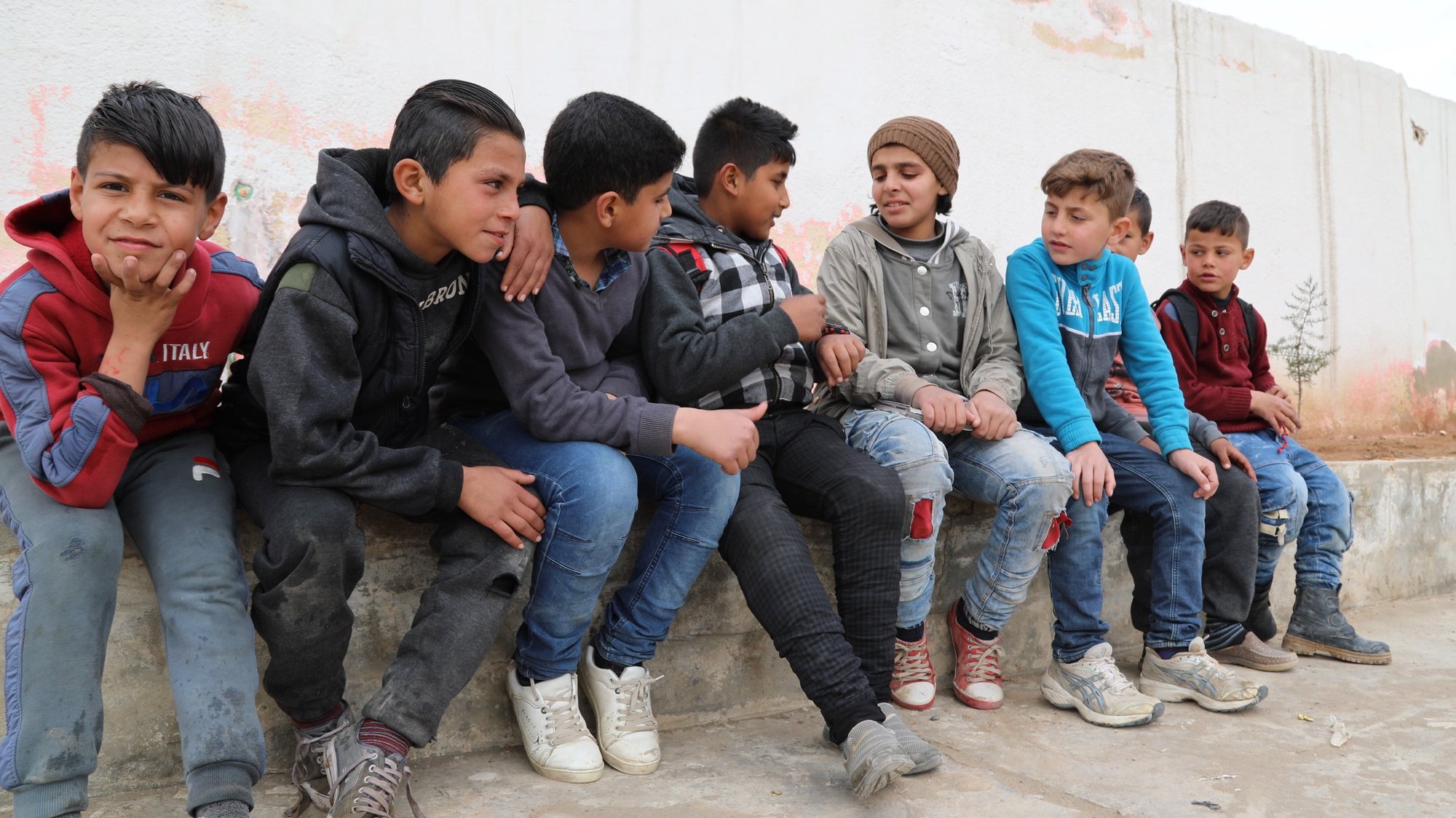 epa07493223 Omar (C), a nine-year-old boy who lost his right leg in a mine explosion, sits with is friends at his school in Raqqa city, northeastern Syria, 01 April 2019 (issued 09 April 2019). The battle of liberation Raqqa from the control of the so-called Islamic State (IS or ISIL or Daesh) group has left at least 1,130 civilians have been killed and another 3,000 people wounded, human rights organizations said.  EPA/AHMED MARDNLI