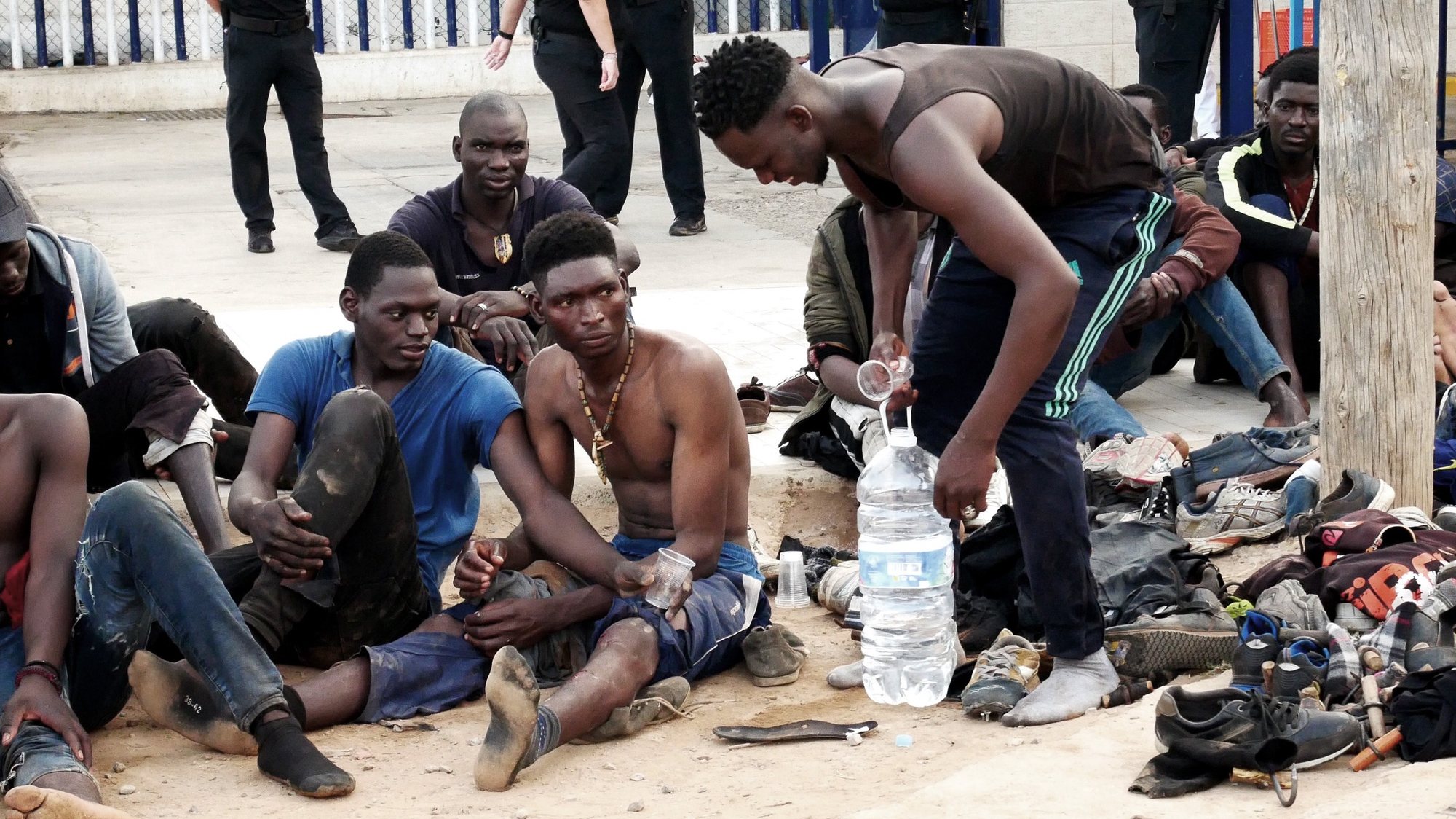epa09357669 Some migrants rest after they managed to reach Spain by jumping the border fence with Morocco, in Melilla, a Spanish enclave in northern Africa, 22 July 2021. Some 300 migrants managed to reach Spain after they massively jumped the border fence in the early morning.  EPA/PAQUI SANCHEZ