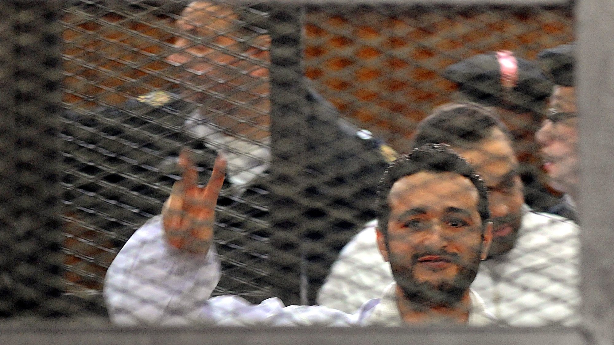 epa04157802 (FILE) A file photo dated 22 December 2013 shows Egyptian activist Ahmed Douma flashing victory sign behind dock bars during his trial in Cairo, Egypt. A Cairo court on 07 April 2014 rejected an appeal by three Egyptian activists against a three-year jail sentence for holding an unauthorized demonstration. Ahmed Maher, founder of the April 6 Youth Movement which played a key role in the 2011 uprising against long-time ruler Hosni Mubarak, and two other activists, Ahmed Douma and Mohamed Adel, were convicted in December of organizing an unauthorized protest and attacking police.  EPA/FOAD GARNOSY ELMAGD / ALMASRY AL BEST QUALITY AVAILABLE - EGYPT OUT