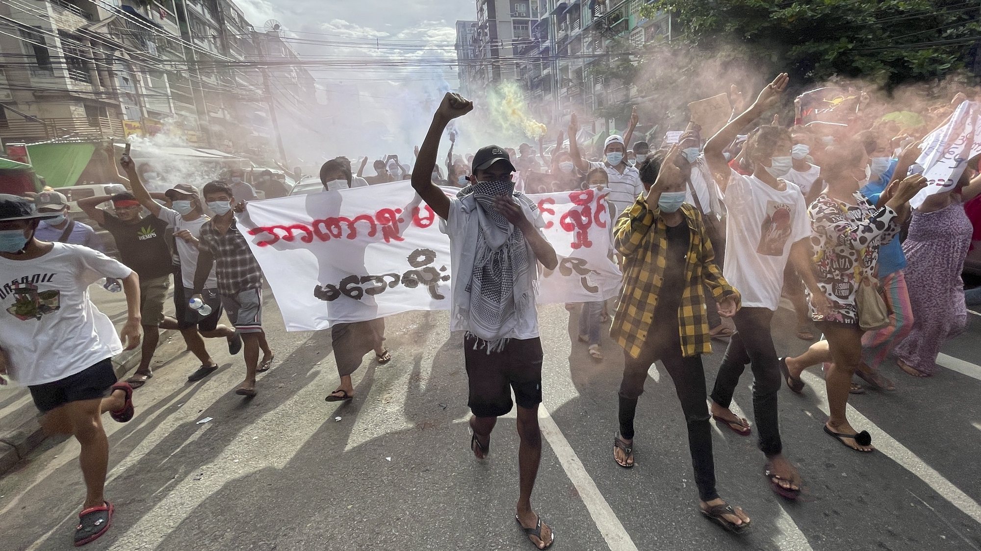 epa09319891 Demonstrators holding posters and flares as they march during an anti-military coup protest at downtown area in Yangon, Myanmar, 03 July 2021. According to the UN Office for the Coordination of Humanitarian Affairs (UN OCHA), at least 230,000 people have been displaced due to violence, armed clashes and insecurity since the military seized power on 01 February 2021.  EPA/STRINGER