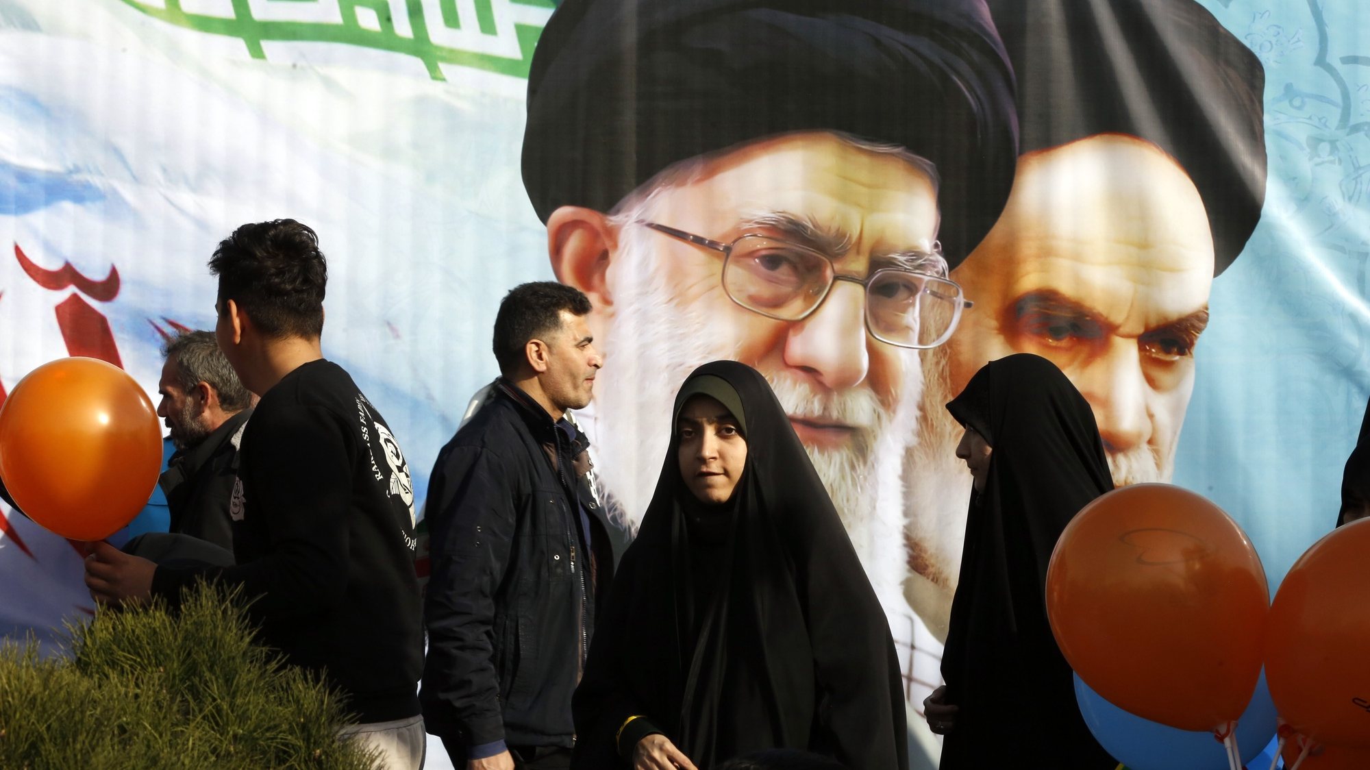 epa11144515 Iranians walk next to pictures of Iranian late Supreme Leader Ayatollah Ruhollah Khomeini (R) and Iranian Supreme Leader Ayatollah Ali Khamenei as they celebrate the 45th anniversary of the Islamic Revolution in Tehran, Iran, 11 February 2024. Iran celebrates the 45th anniversary of the Islamic Revolution on 11 February 2024, in which the monarchy system was toppled and the Islamic Republic was formed, with Ayatollah Ruhollah Khomeini serving as Iran&#039;s first Supreme Leader.  EPA/ABEDIN TAHERKENAREH