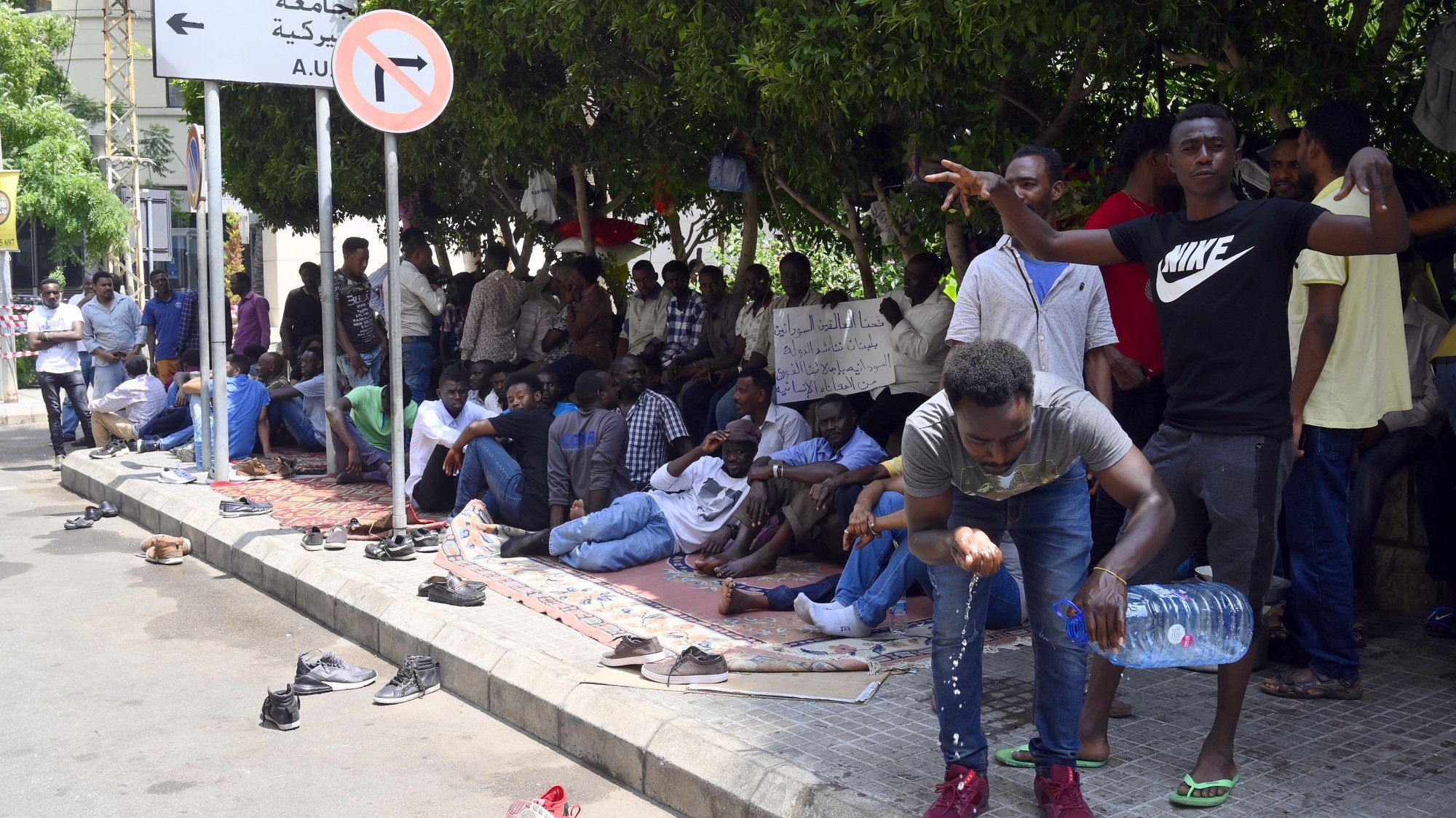 epa08524805 Sudanese workers sit on the floor during a protest in front of their country’s Embassy in Beirut, Lebanon, 03 July 2020. According to a spokesperson on behalf of the protesters, there are about 3,000 Sudanese workers stuck in Lebanon. He added that the Sudanese government has repatriated workers from the Emirates and Qatar, but disregarded those stuck in both Lebanon and Libya. Numerous foreign domestic and migrant workers are suffering the consequences of the economic crisis in Lebanon due to a shortage of dollars, these workers are unable to get their salaries in USD as per their contracts.  EPA/WAEL HAMZEH