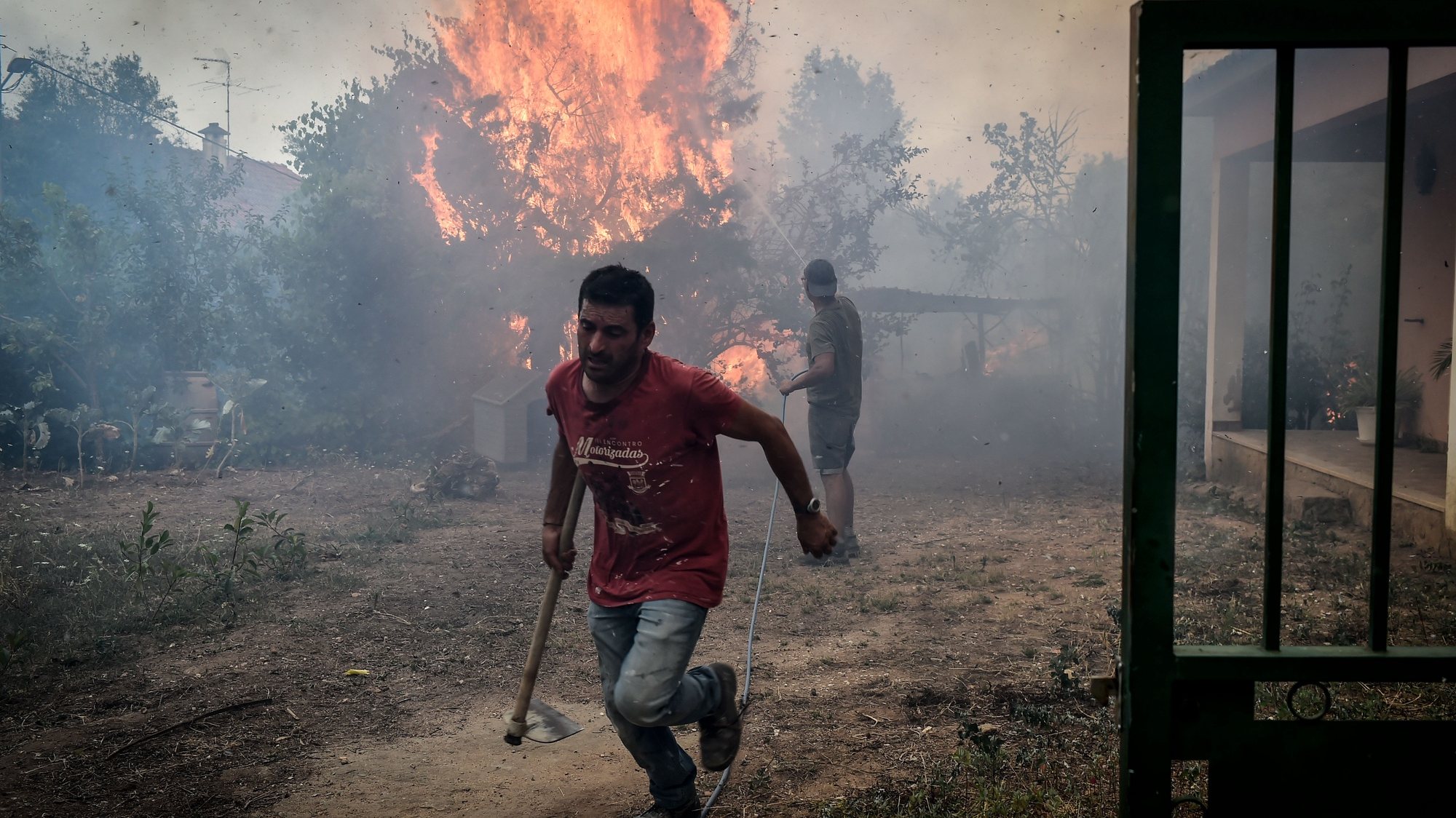 Men fight a wildfire burning in the village of Aventeira, Alvaiázere, Portugal, July 12, 2022. The fire that cutted the A1 highway between Pombal and Leiria and surrounded the village of Aventeira (Alvaiázere) has 350 operatives, supported by 103 vehicles and two aircraft. NUNO ANDRE FERREIRA/LUSA