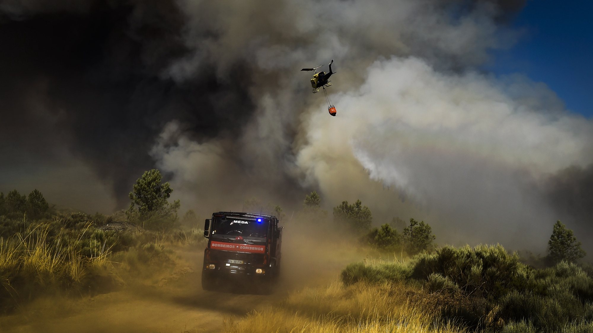 Um helicóptero combate um incêndio na freguesia de Rapa, Celorico da Beira, Guarda, 13 de agosto de 2022. De acordo com a página da Autoridade Nacional de Emergência e Proteção Civil, o incêndio está a ser combativo por 1327 operacionais, apoiados por 392 viaturas e 3 meios aéreos. NUNO ANDRÉ FERREIRA/LUSA