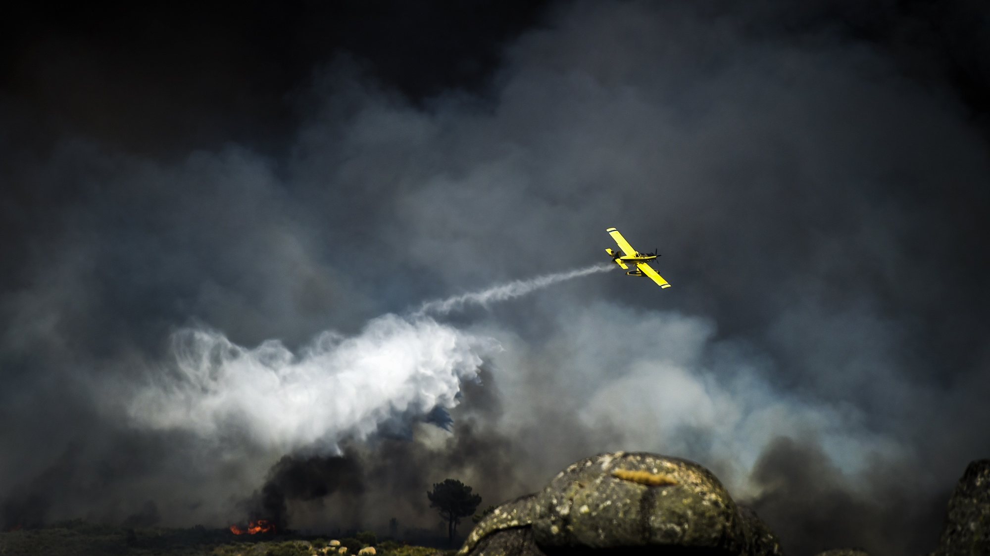 epa10119196 An airplane drops water over a forest fire in Rapa, Celorico da Beira, Guarda, Portugal, 13 August 2022. At the moment 1327 operational, 392 vehicles and three airplane are fighting the forest fire.  EPA/NUNO ANDRE FERREIRA