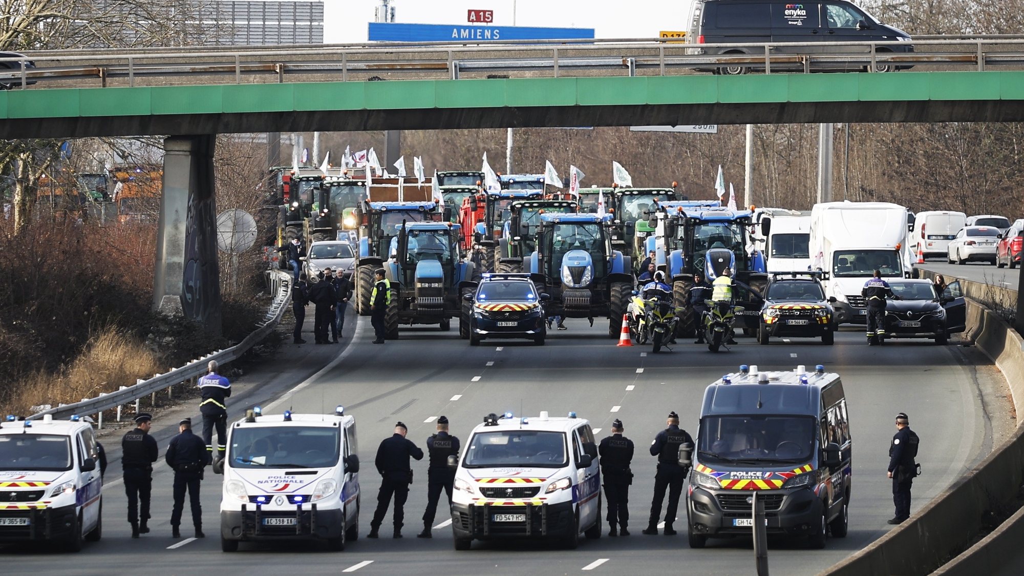 epa11112555 Police officers watch over dozens of tractors taking part in a demonstration on the A15 motorway near Argenteuil, north of Paris, France, 29 January 2024. French farmers continue their protests with road blockades and demonstrations in front of state buildings awaiting a response from the government to their request for &#039;immediate&#039; aid of several hundred million euros. On 23 January, the EU Agriculture and Fisheries Council highlighted the importance of providing the conditions necessary to enable EU farmers to ensure food security sustainably and profitably, as well as ensuring a fair income for farmers.  EPA/YOAN VALAT