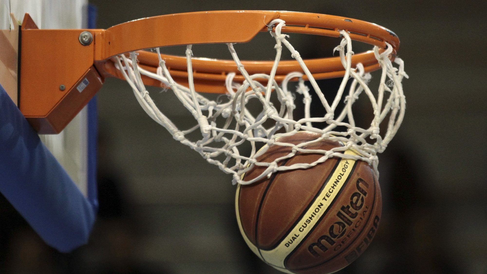 Bola entra no cesto durante um jogo de basquetebol