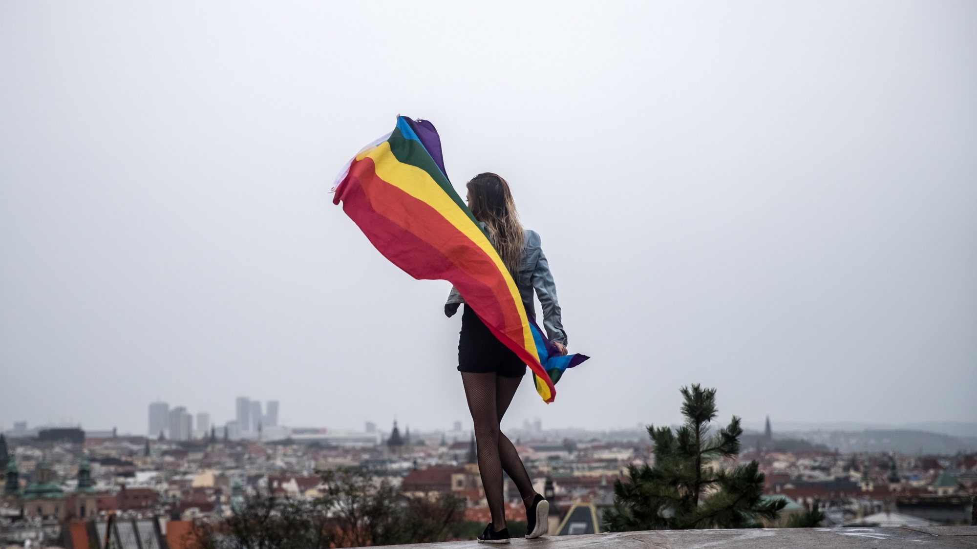 epa07766222 A woman wrapped in the rainbow flag pose for picture for her friend during the Prague Pride parade in downtown Prague, Czech Republic, 10 August 2019. Several thousands of people attended the 9th Prague Pride to support the LGBT (lesbian, gay, bisexual and transgender) communities.  EPA/MARTIN DIVISEK