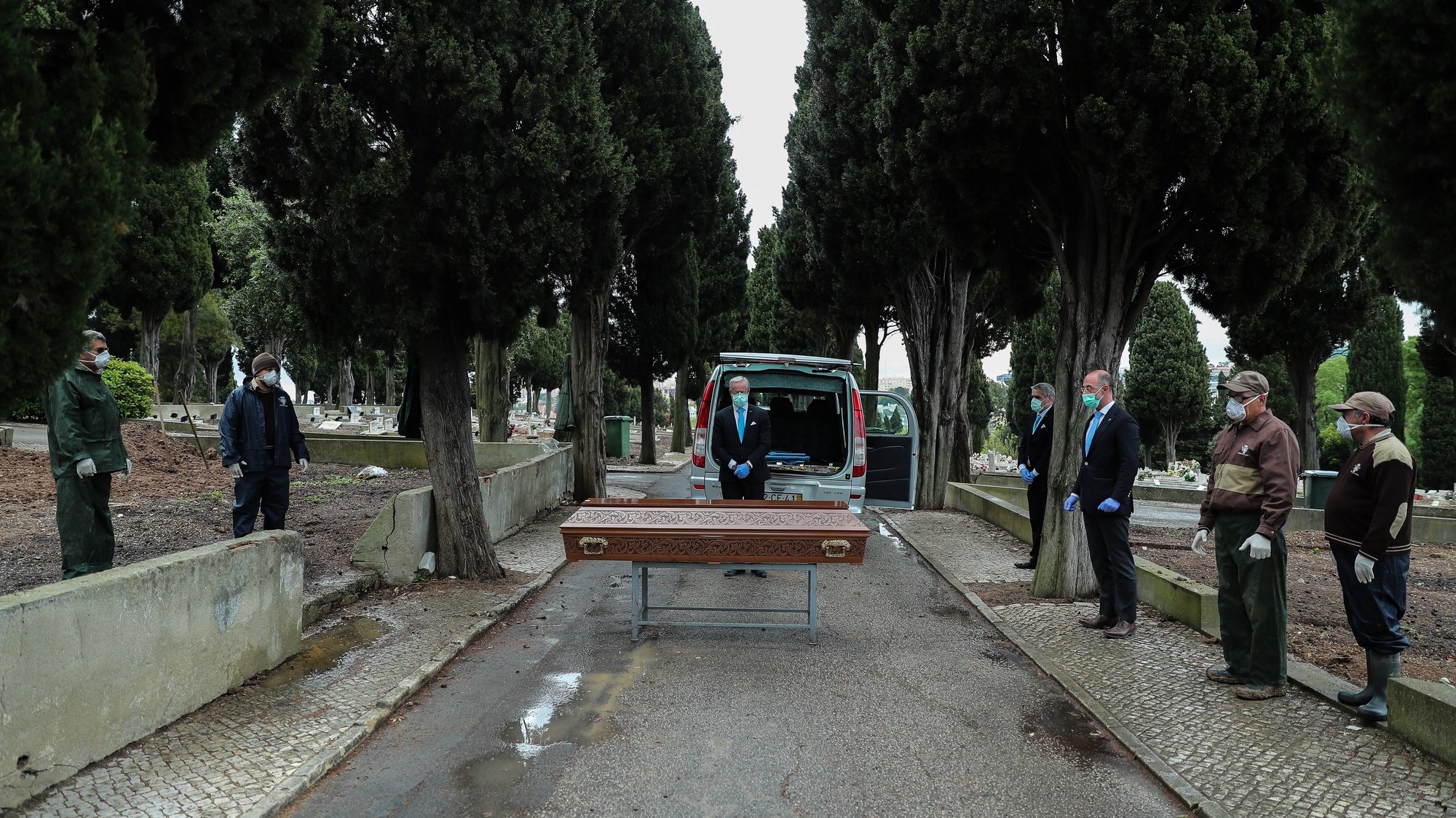 epa08347884 Employees of a funeral home and gravediggers at Benfica cemetery wearing protective masks pay respect to a woman about 30 years old who died of cancer, during the funeral ceremony, in Lisbon, Portugal, 01 April 2020 (Issued 07 April 2020). Portugal is in state of emergency until 17 April 2020. Countries around the world are taking increased measures to stem the widespread of the SARS-CoV-2 coronavirus which causes the Covid-19 disease.  EPA/MIGUEL A. LOPES  ATTENTION: This Image is part of a PHOTO SET