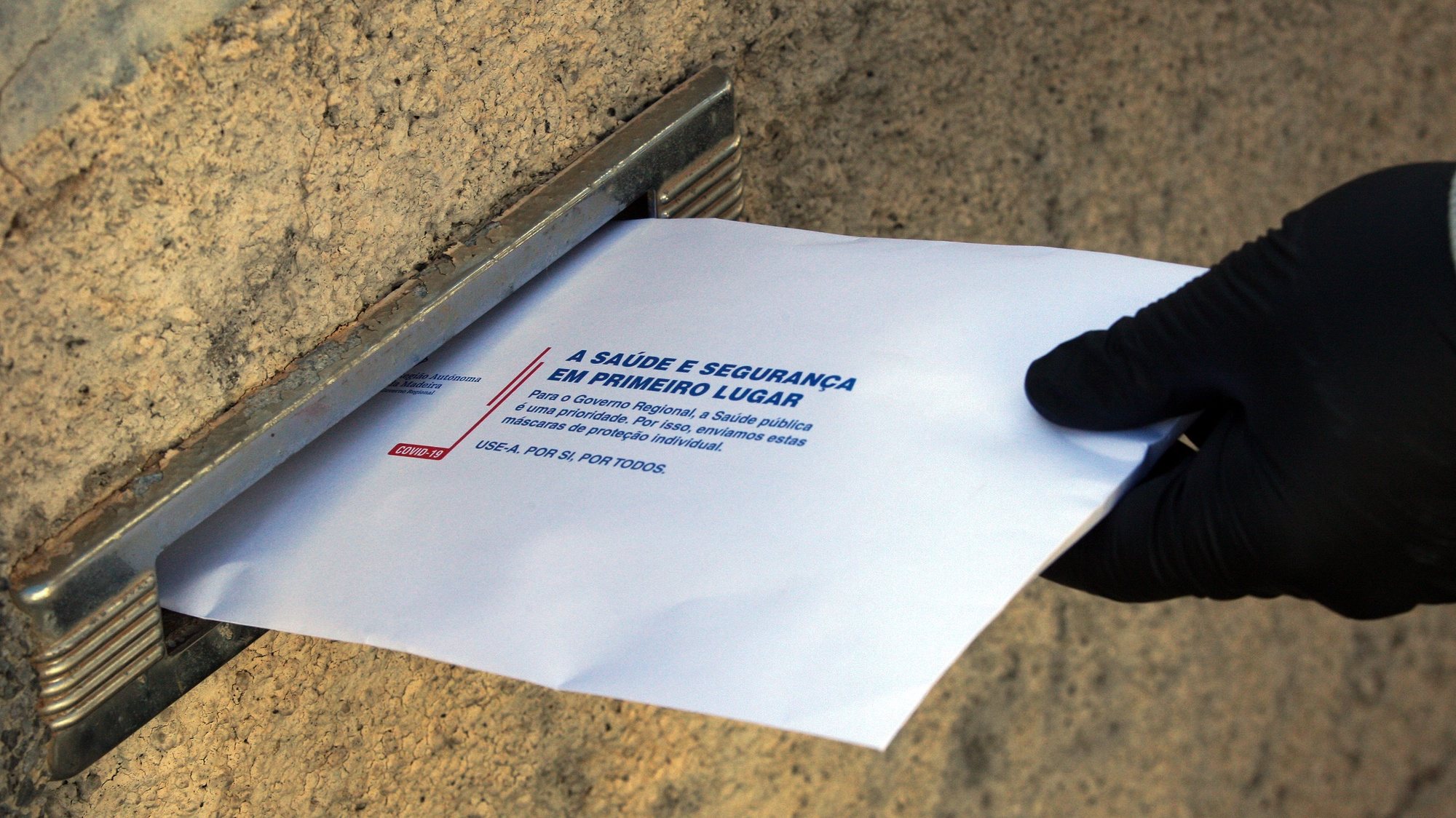 Décio Farinha, carteiro dos CTT Madeira, entrega envelopes enviados pelo Governo Regional contendo máscaras de proteção contra a covid-19, no Funchal, ilha da Madeira, 17 de abril de 2020. HOMEM DE GOUVEIA/LUSA