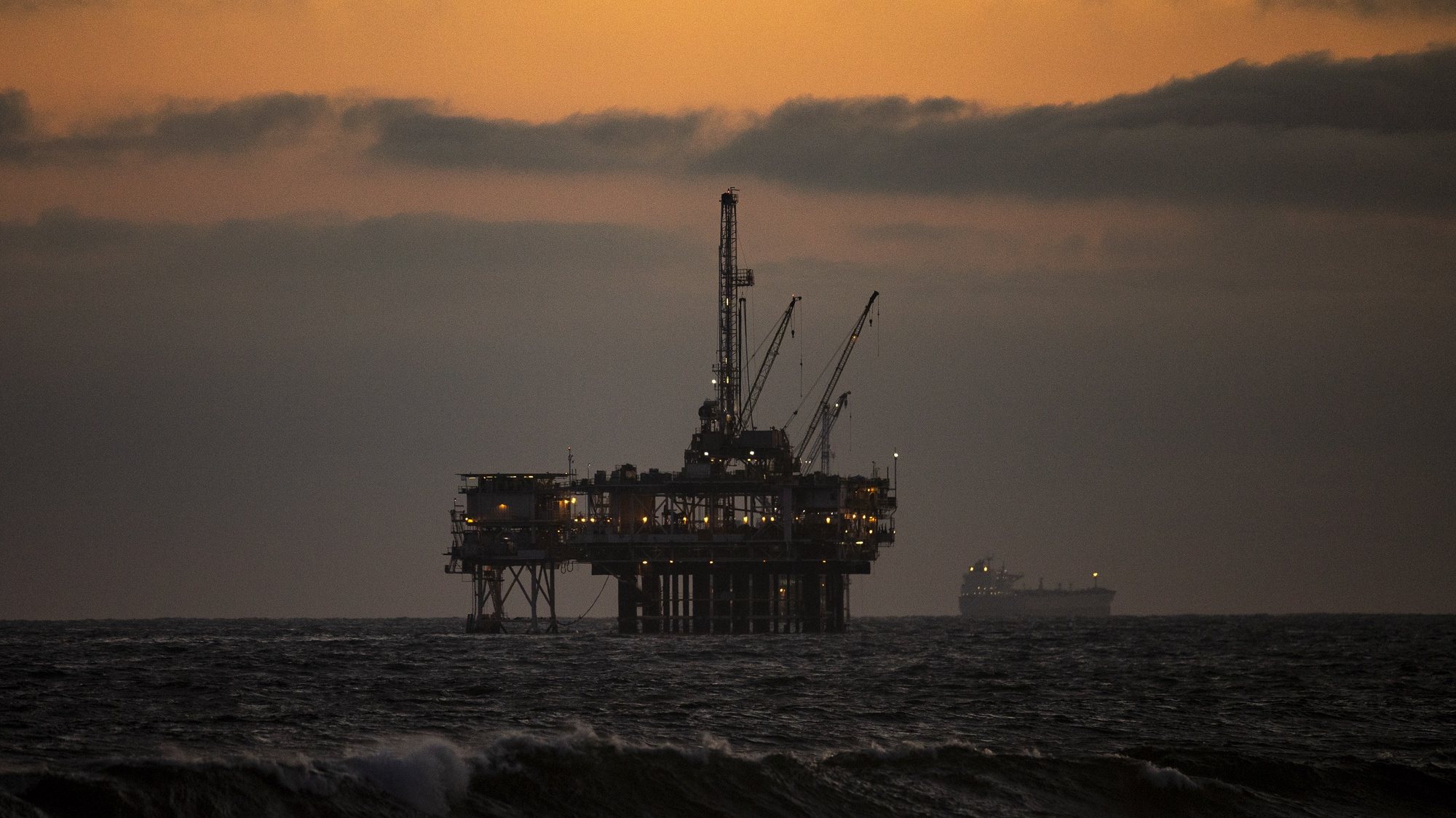 epa08416024 An oil rig sits off the shore at sunset in Huntington Beach, California, 11 May 2020. California begane it&#039;s Phase 2 of reopening, after coronavirus restrictions, on 08 May 2020.  EPA/ETIENNE LAURENT