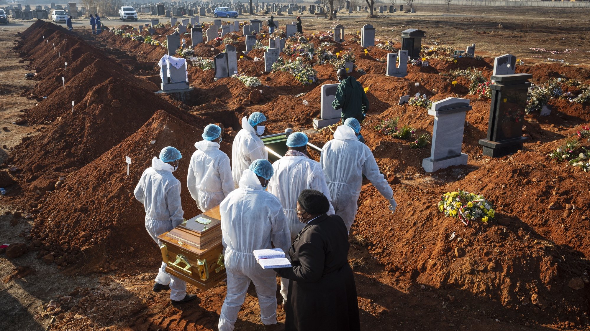 epa08667919 The coffin of a victim of the Covid-19 Corona virus being taken to her grave by relatives at a burial ground in Johannesburg, South Africa, 24 July 2020 (reissued on 14 September 2020). The National Funeral Practitioners Association of SA (Nafupa) have threatened a 3-day strike starting on 14 September after the government tightened legislation regarding undertakers working conditions. The strike would mean bodies of deceased would not be collected from old age homes, hospitals and morgues for three days, that might lead to possible heath issues.  EPA/KIM LUDBROOK