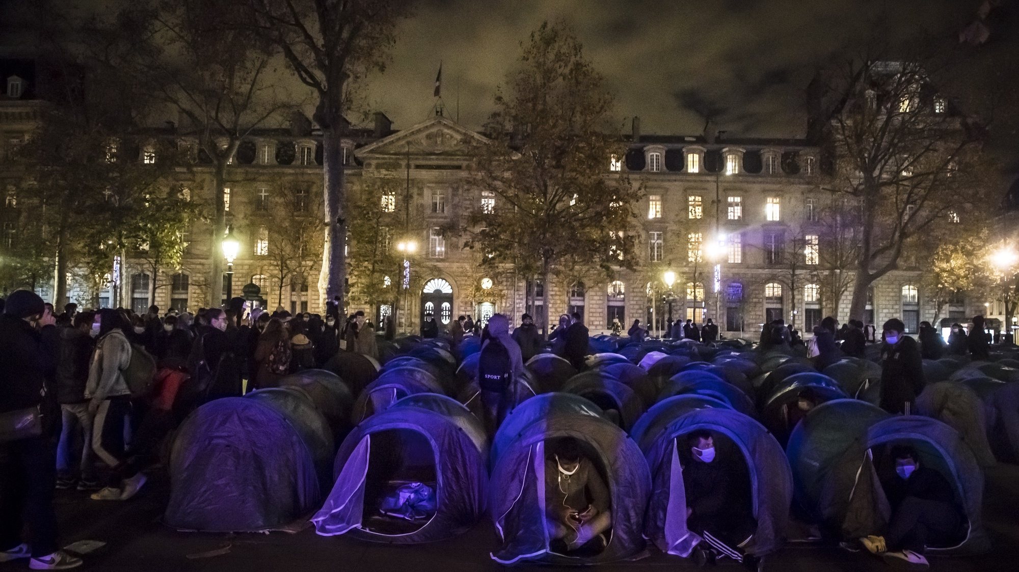 epa08838230 Migrants wait in their tents as hundreds of migrants and refugees evacuated from a makeshift migrant camp in Saint-Denis on 17 November, install tents with the support of associations and organisations on Republic Square in Paris, France, 23 November 2020.  EPA/CHRISTOPHE PETIT TESSON
