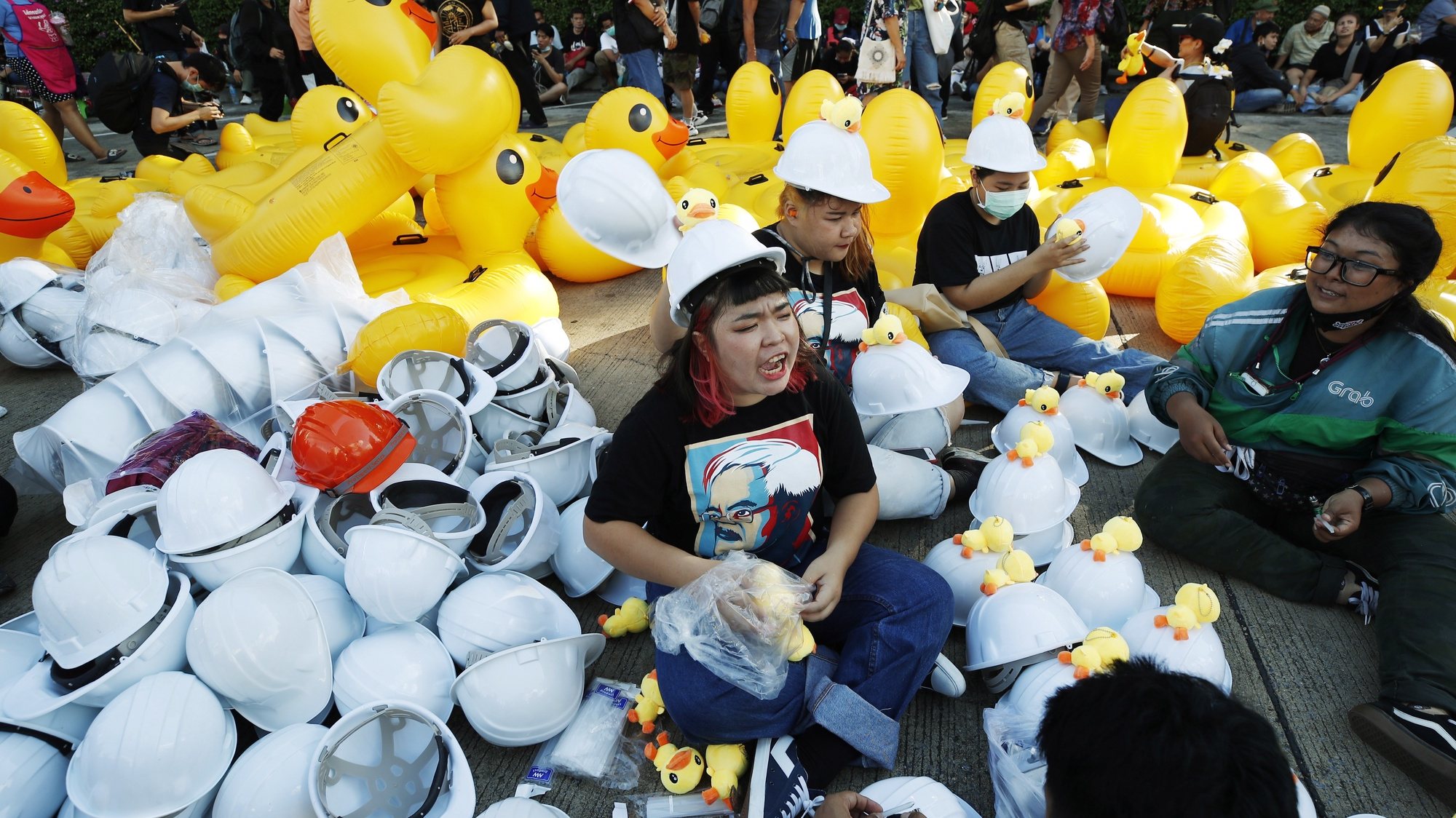 epaselect epa08840410 Protesters glue rubber ducks onto helmets to be distributed to other protesters ahead of an anti-government protest calling for monarchy reform at the Siam Commercial Bank headquarters in Bangkok, Thailand, 25 November 2020. Pro-democracy protesters held a mass rally calling for the monarchy reform and to demand public oversight of the king&#039;s assets at the Siam Commercial Bank where Thai King Maha Vajiralongkorn is a major shareholder of the bank.  EPA/DIEGO AZUBEL