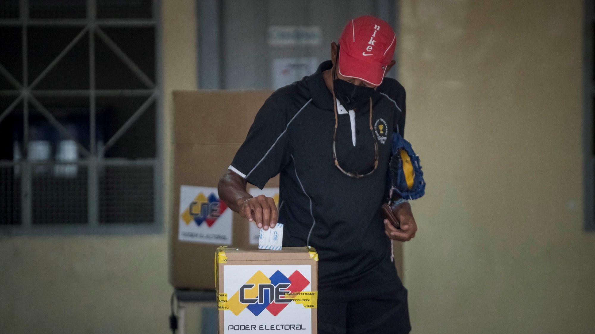 epa08867315 A voter casts his vote in a ballot box in a polling station during Parliamentary elections, in Caracas, Venezuela, 06 December 2020. Venezuelans were called to polls to select 277 members of the National Assembly. The opposition has called for a boycott of the elections, on grounds that the contest will not be free and fair.  EPA/Miguel Gutierrez