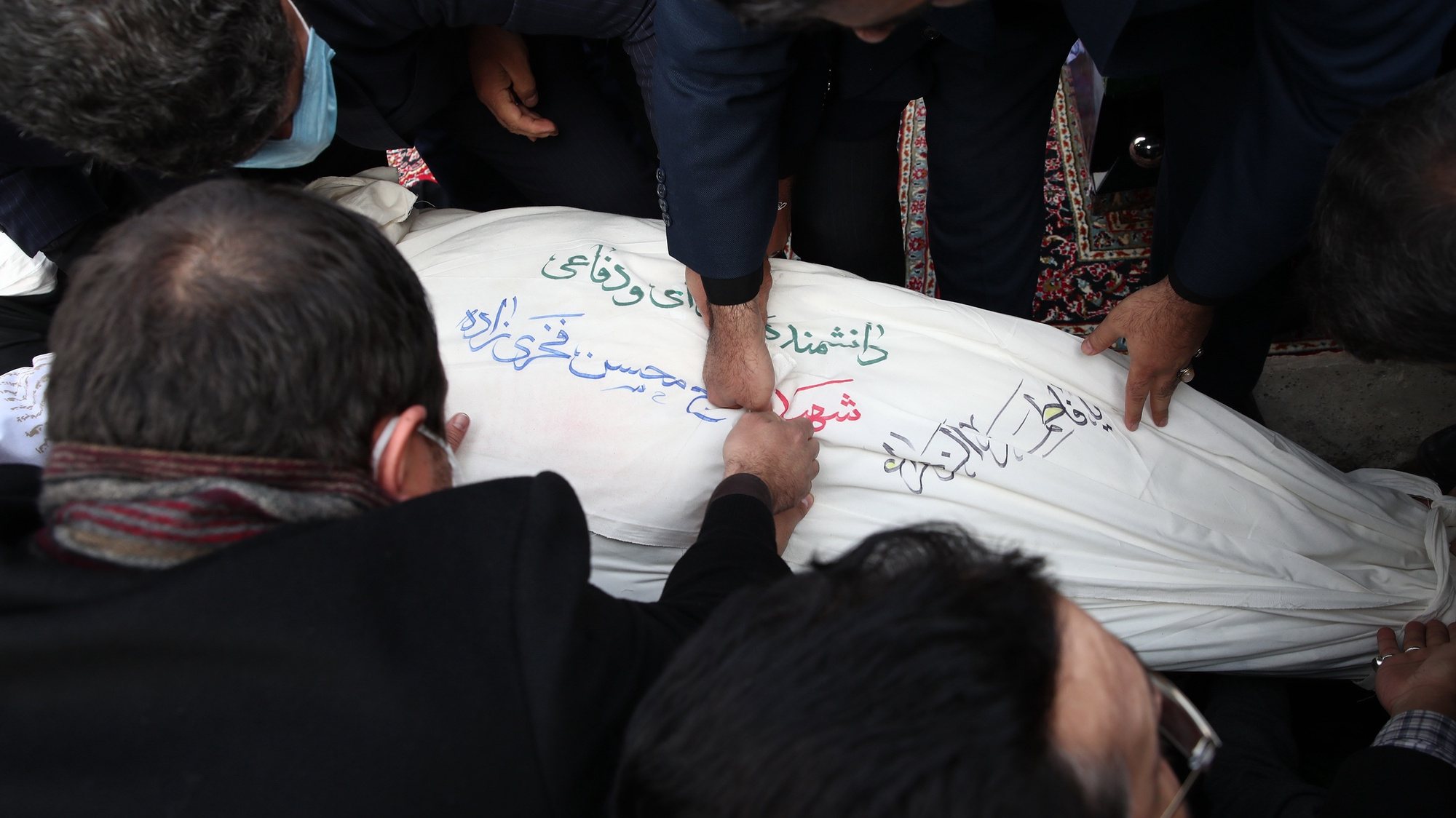 epa08853374 A handout photo made available by the Iranian defence ministry office shows relatives and officials prays over the body of slain Iranian nuclear scientist Mohsen Fakhrizadeh during the burial ceremony at Saleh shrine in northern Tehran, Iran, 30 November 2020. Media reported that Iran blamed Israel for the assassination of Mohsen Fakhrizadeh, a senior Iranian nuclear scientist.  EPA/DEFENCE MINISTRY OFFICE HANDOUT  HANDOUT EDITORIAL USE ONLY/NO SALES