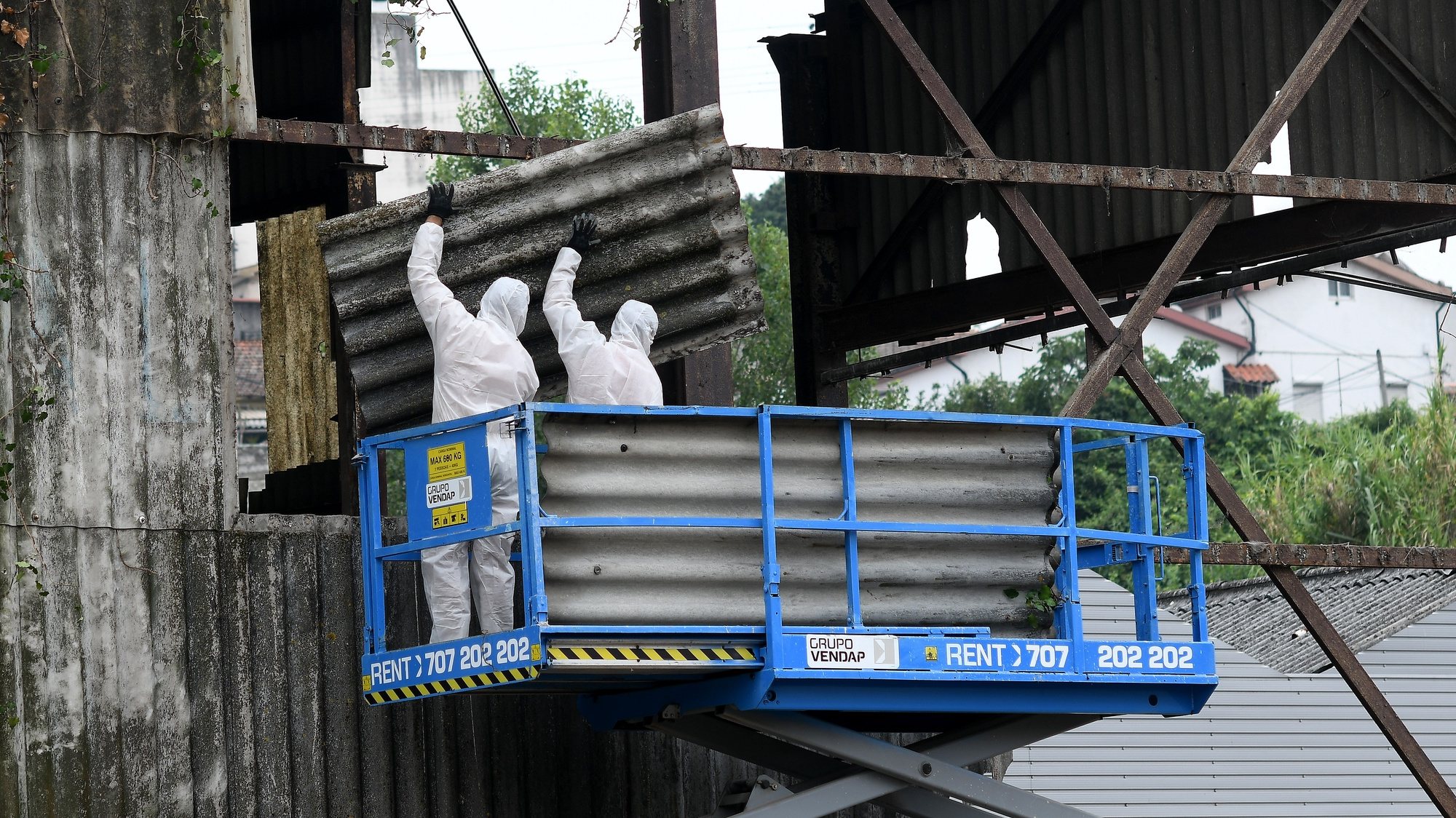 Dois técnicos removem placas de fibrocimento com amianto de fábrica desativada em Rio Tinto, Porto, 17 de julho de 2019. HUGO DELGADO/LUSA