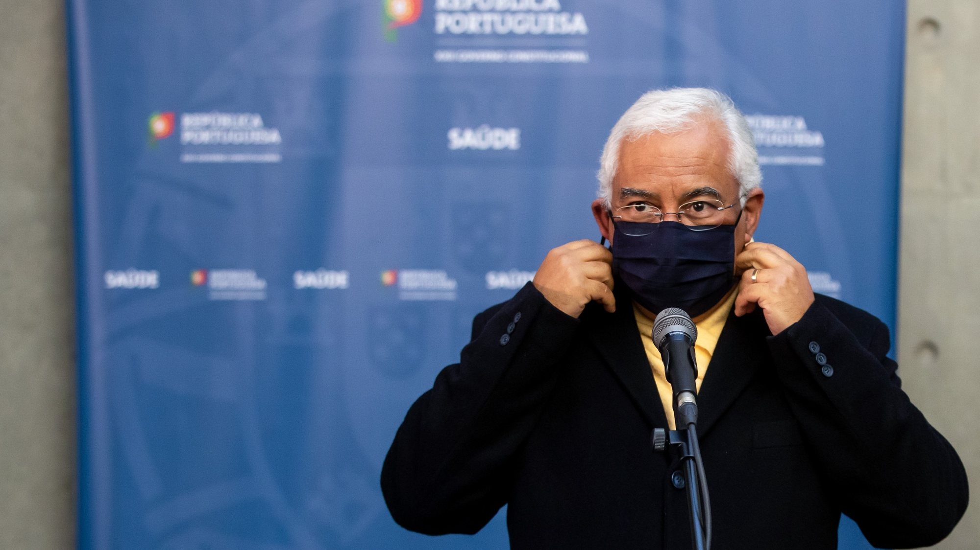 O primeiro-ministro, António Costa, retira a máscara protetora contra a Covid-19 antes de prestar declarações aos jornalistas após a 14ª sessão de apresentação da “Situação epidemiológica da Covid-19 em Portugal”, na sede do Infarmed, em Lisboa, 12 de janeiro de 2021. JOSÉ SENA GOULÃO/LUSA