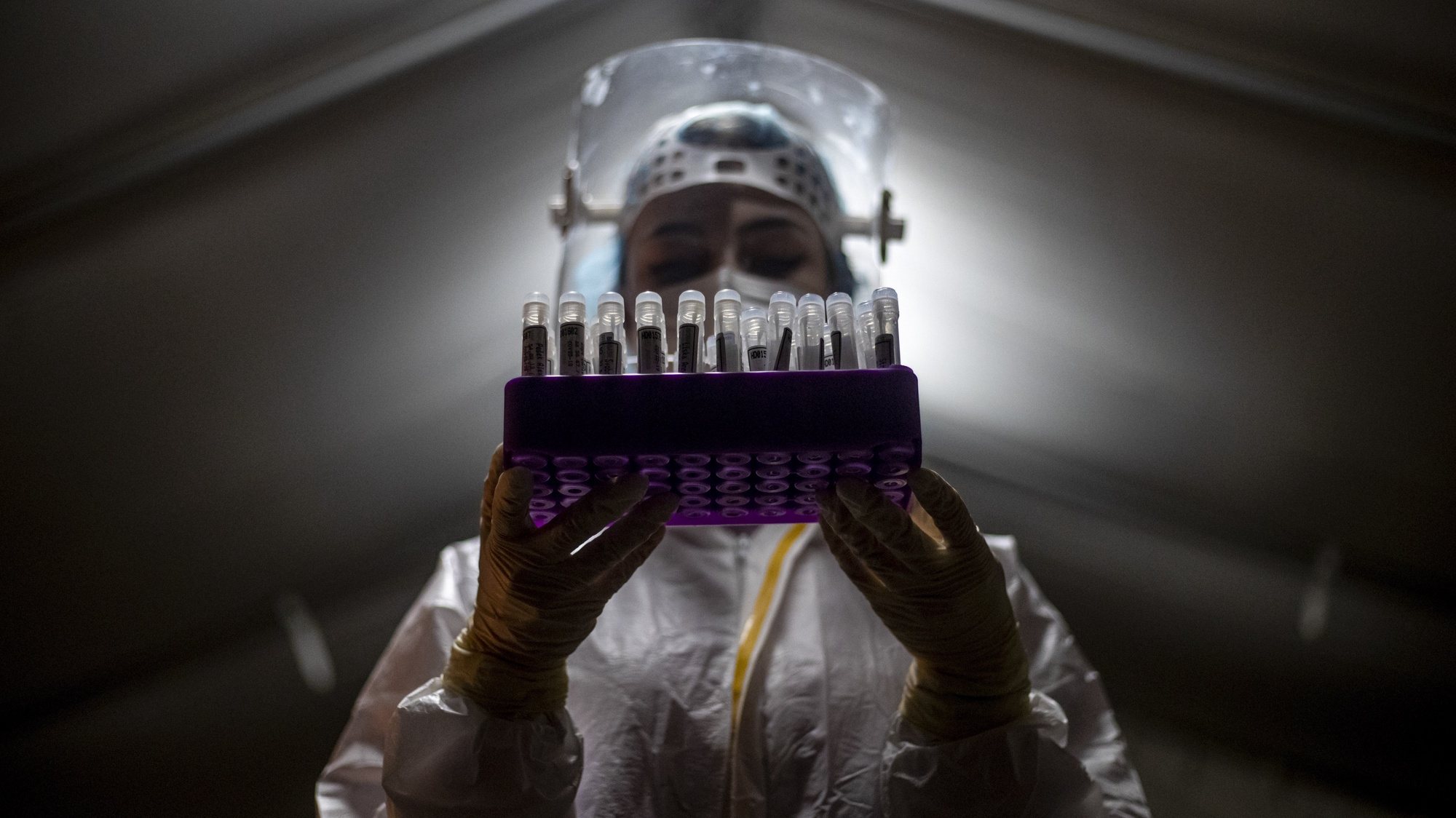 epa08980351 A medical worker wearing personal protective equipment (PPE) poses with swab samples at drive-in coronavirus testing station in Prague, Czech Republic, 01 February 2021. The Czech Republic has seen a stagnating trend in new SARS-CoV-2 infections as Czech government announced on 28 January 2021 new measures in connection with the COVID-19 pandemic.  EPA/MARTIN DIVISEK