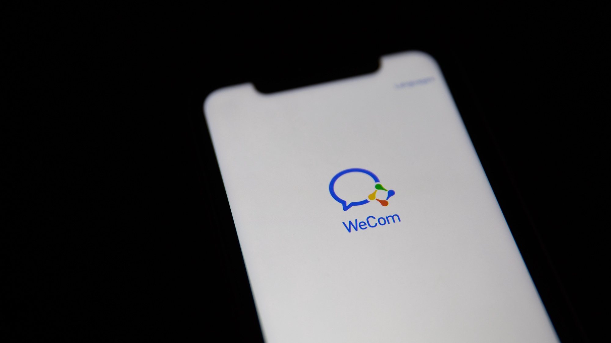 epa08685862 A generic illustration shows the logo of Chinese internet media app WeCom on a phone, in Beijing, China, 21 September 2020. According to media reports, Chinese tech giant Tencent has changed the name of its WeChat Work office collaboration app to WeCom, as an alternative to its WeChat app which was set to stop operation in the U.S. on midnight 20 September 2020.  EPA/ROMAN PILIPEY