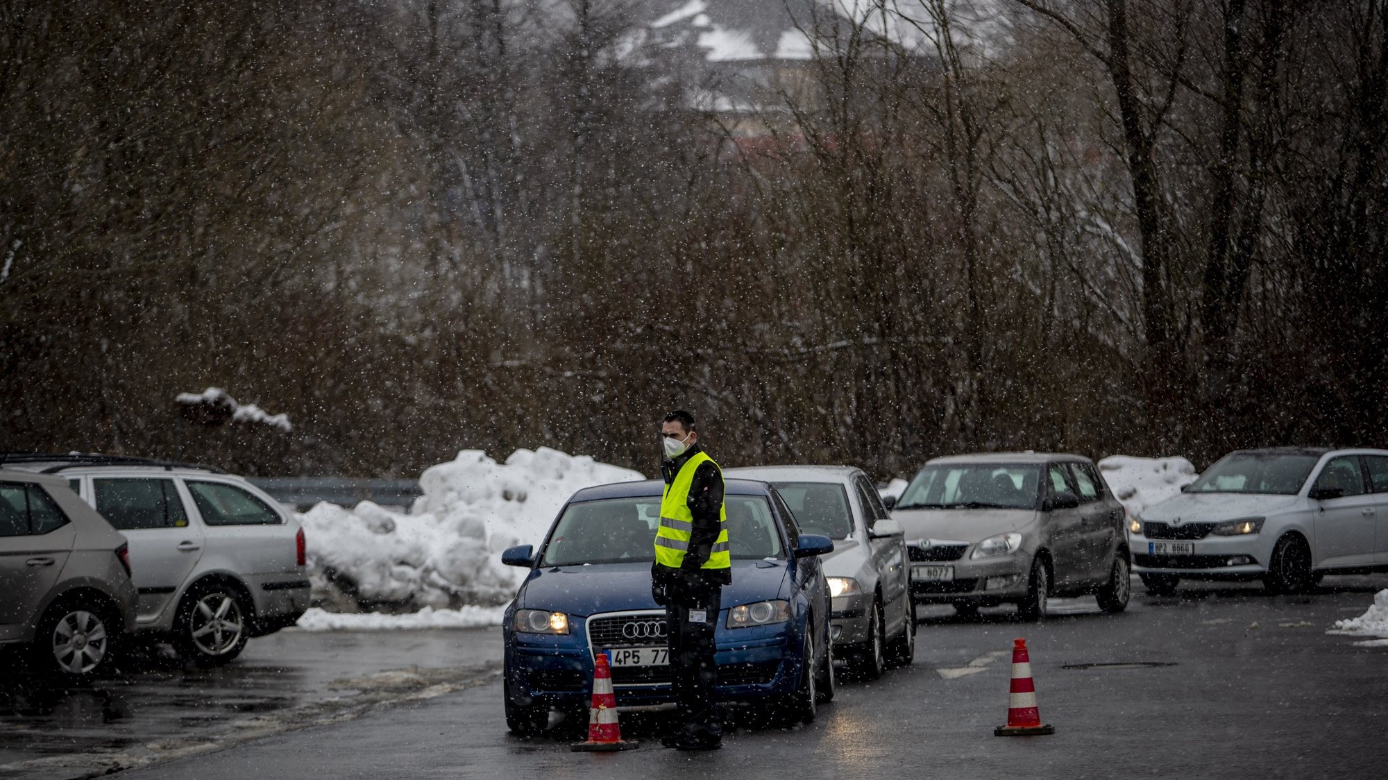 epa08964255 A security member stops car with cross-border workers as they arrive for Covid-19 antigen testing at parking lot in Folmava, Czech-Germany border, 25 January 2021. Germany put the Czech Republic in the list of COVID-19 high-risk countries, implementing stricter measures for cross-border commuters from 24 January 2020. When traveling to Bavaria, cross-border workers must now produce a negative test every two days, resulting in long queues at border crossings.  EPA/MARTIN DIVISEK