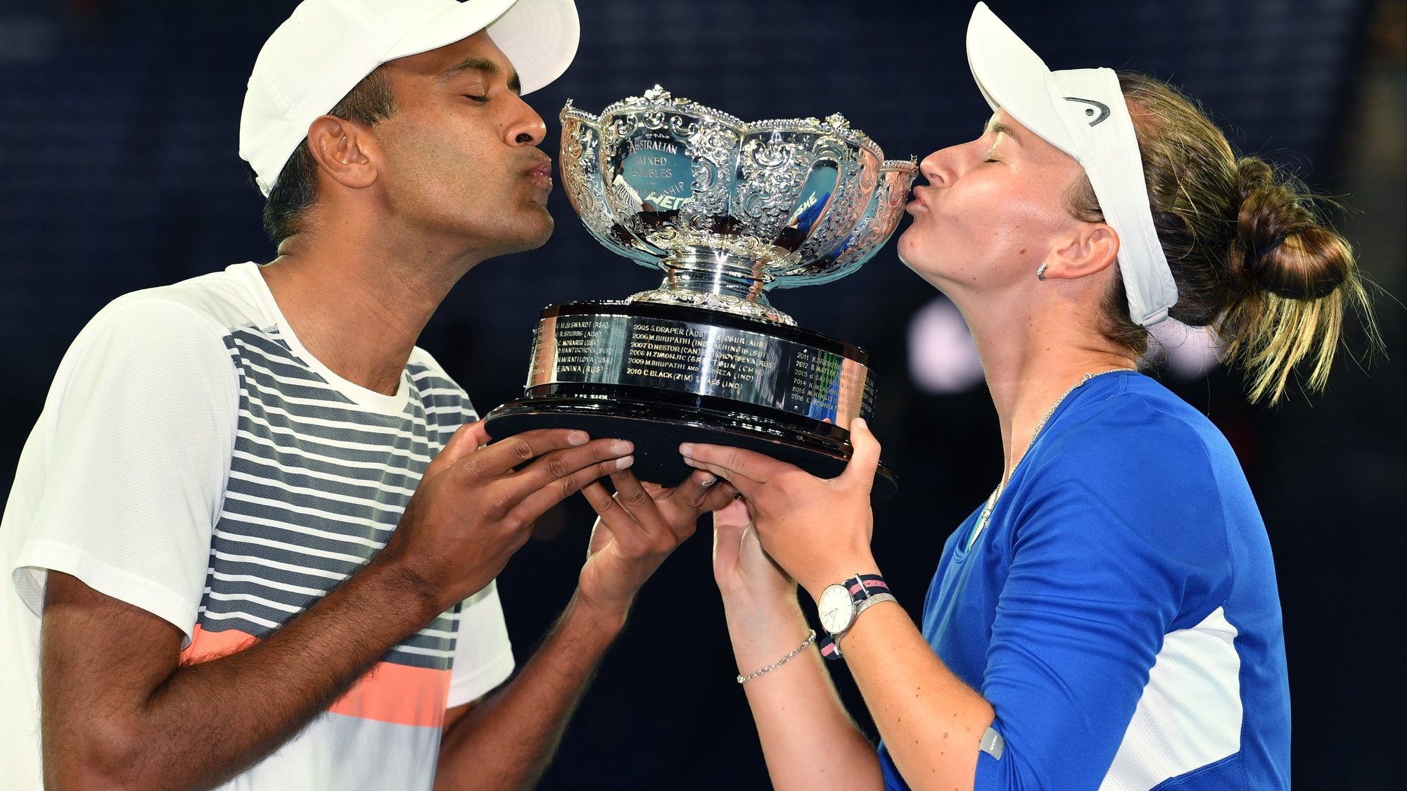 epa09025643 Barbora Krejcikova of the Czech Republic and Rajeev Ram of the United States kiss the trophy after winning the mixed doubles final against Matthew Ebden and Samantha Stosur of Australia on day 13 of the Australian Open tennis tournament at Rod Laver Arena in Melbourne, Australia, 20 February 2021.  EPA/DEAN LEWINS  AUSTRALIA AND NEW ZEALAND OUT