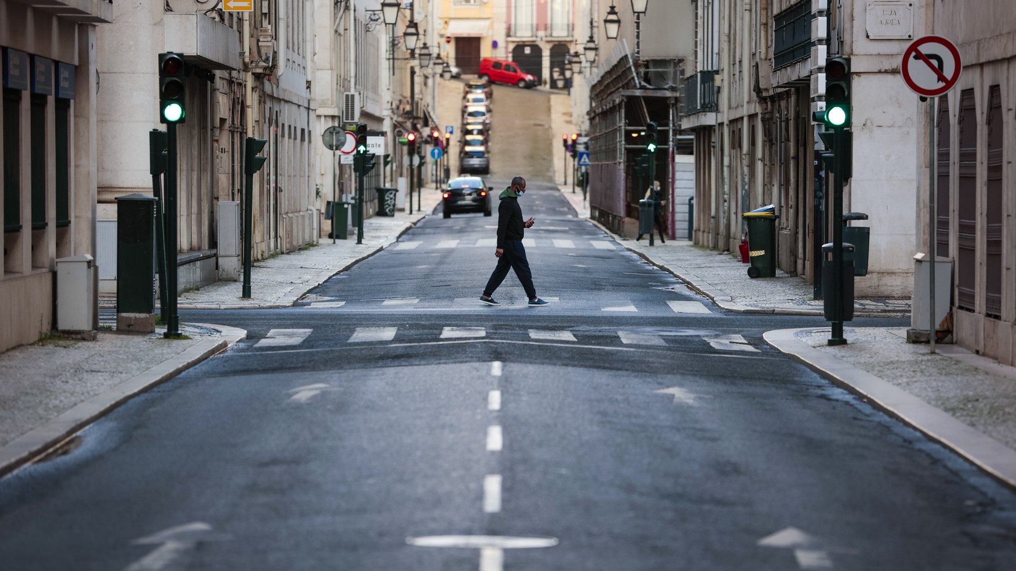 Um homem atravessa uma rua da baixa lisboeta a meio da tarde, em Lisboa, 05 de dezembro de 2020. Entre as 13:00h de sábado 05 de dezembro e as 05:00h de 06 dezembro, está em vigor o recolher obrigatório nos concelhos de risco &quot;extremamente elevado&quot; e &quot;muito elevado&quot;. JOSÉ SENA GOULÃO/LUSA
