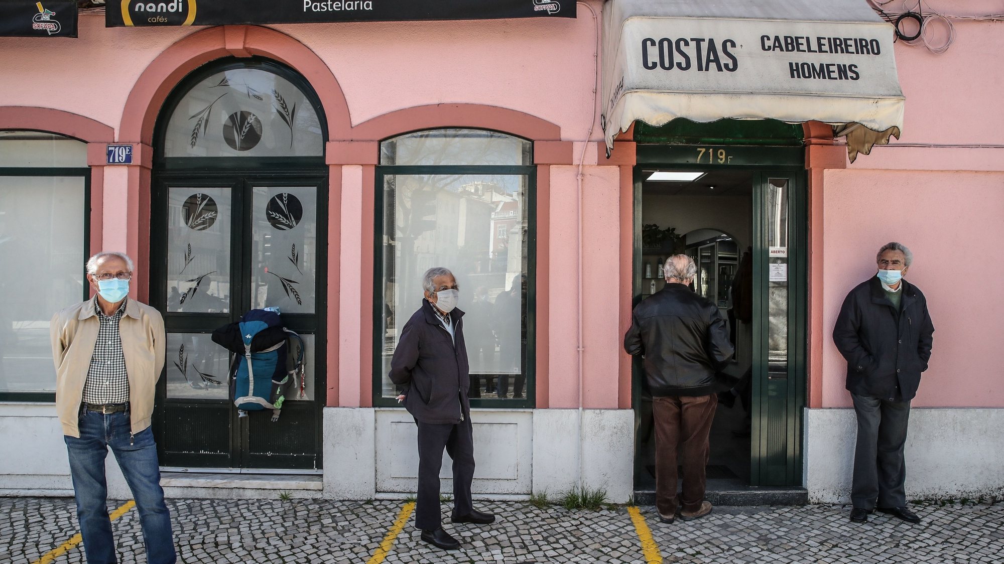 Populares aguardam a vez frente a uma barbearia após a reabertura de comércio não-essencial e cabeleireiros fechado anteriormente após novo decreto do Estado de Emergência devido à covid-19, Lisboa, 15 março 2021.  MANUEL DE ALMEIDA / LUSA