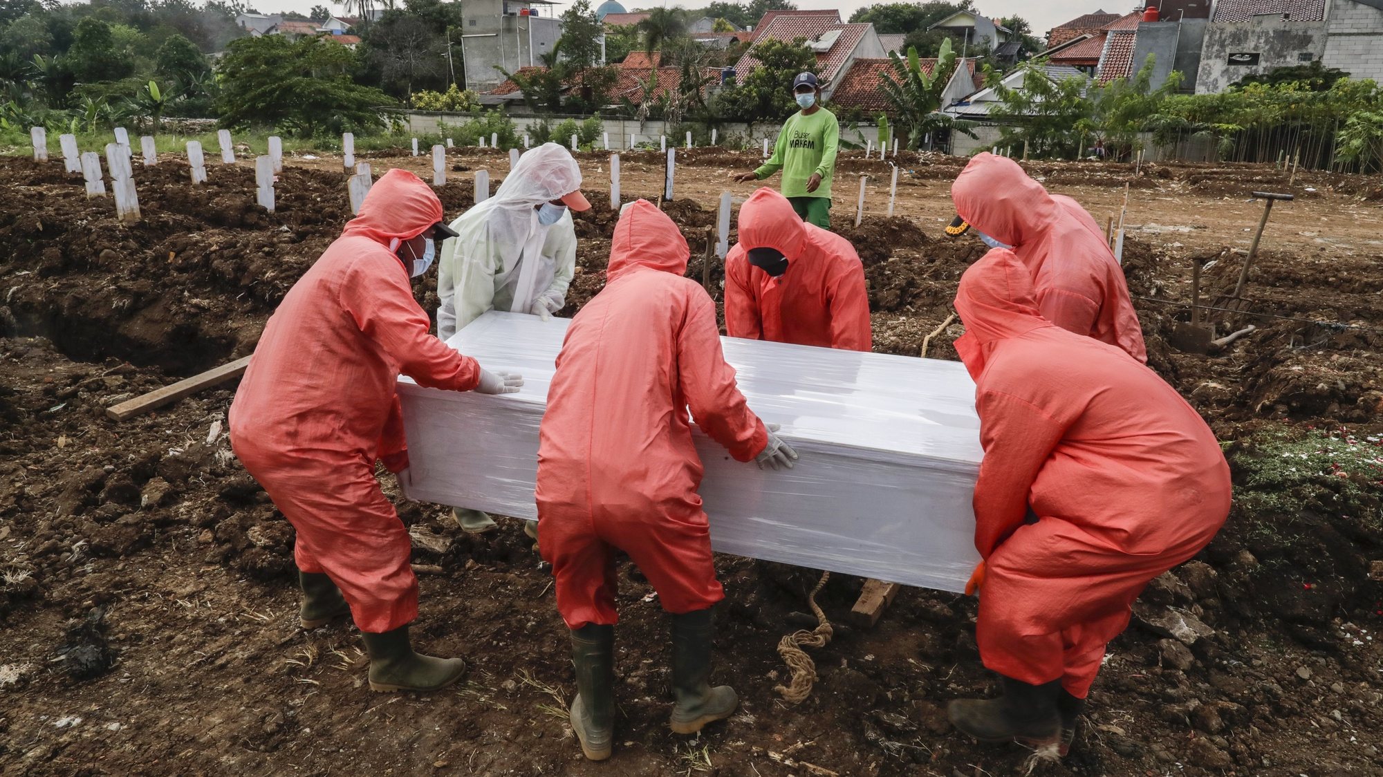 epa09098373 Workers clad in hazmat suits carry the coffin containing the body of a COVID-19 victim during a funeral at Srengseng Sawah cemetery in Jakarta, Indonesia, 26 March 2021. Indonesia is one of the countries worst hit by COVID-19 in Asia, with more than one million cases and more than forty thousands deaths since the pandemic began.  EPA/MAST IRHAM