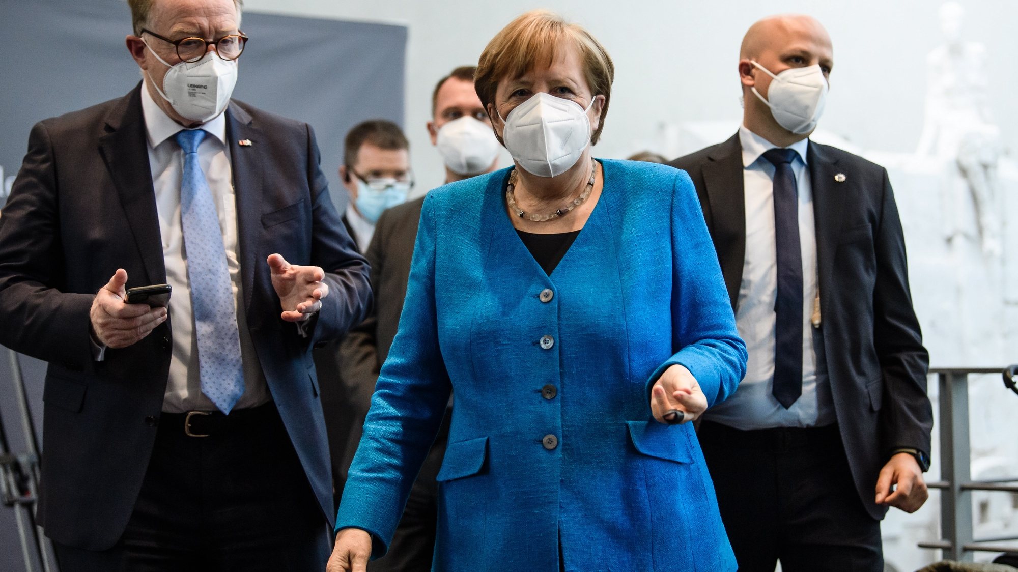 epa09154835 German Chancellor Angela Merkel (C) walks back into the hearing room next to deputy chairman of the Wirecard investigation committee Hans Michelbach (L) after a break of a session of the Wirecard investigation committee at Paul-Loebe-Haus in Berlin, 23 April 2021. The committee is dealing with the scandal related to the market manipulation of service provider Wirecard.  EPA/CLEMENS BILAN