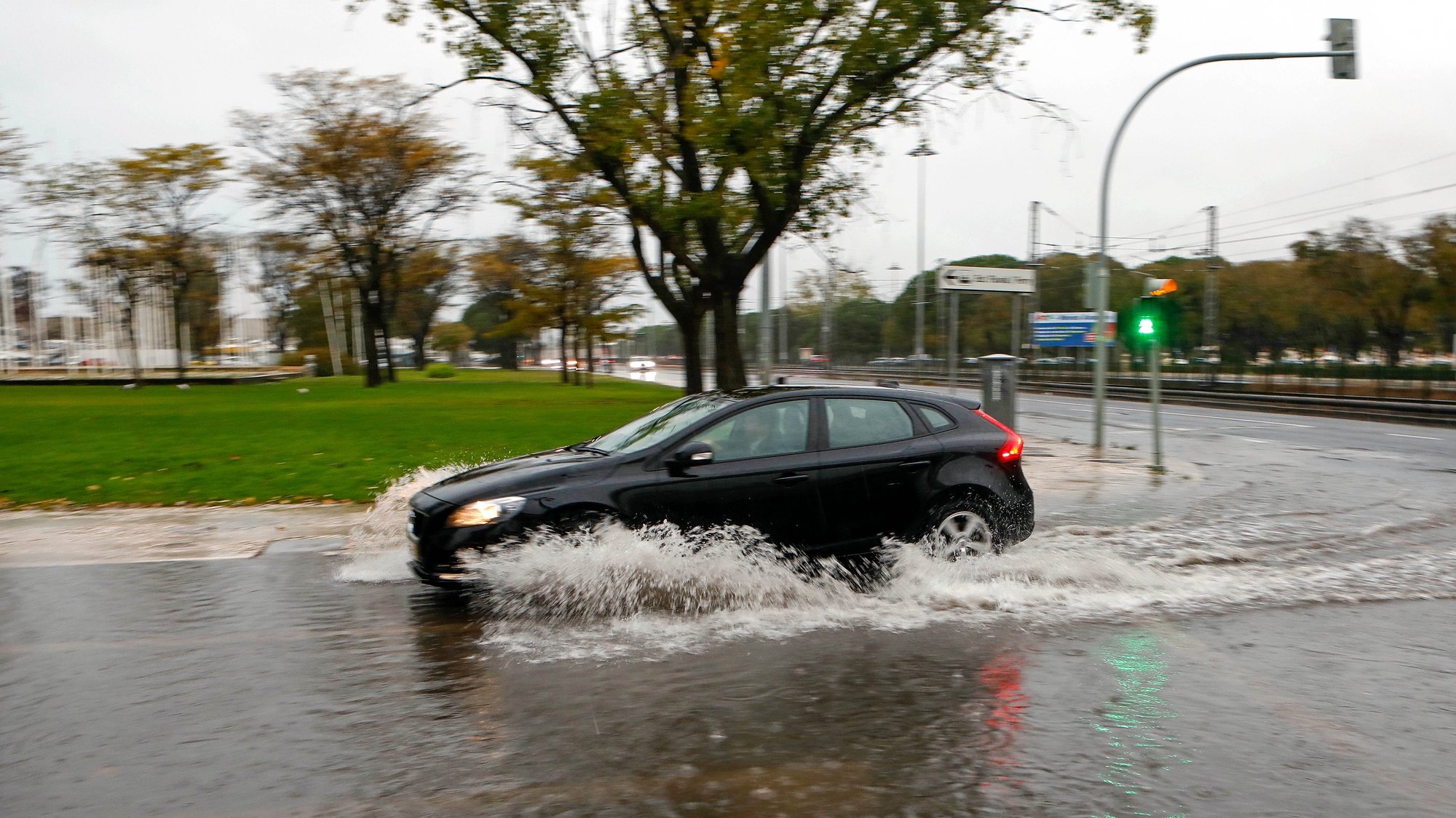 Um automóvel passa por uma estrada alagada pelas chuvas na zona de Belém, Lisboa, 11 de novembro de 2018. A chuva intensa que se abateu na manhã deste domingo sobre o distrito de Lisboa está a provocar inundações em várias localidades. ANTÓNIO PEDRO SANTOS/LUSA