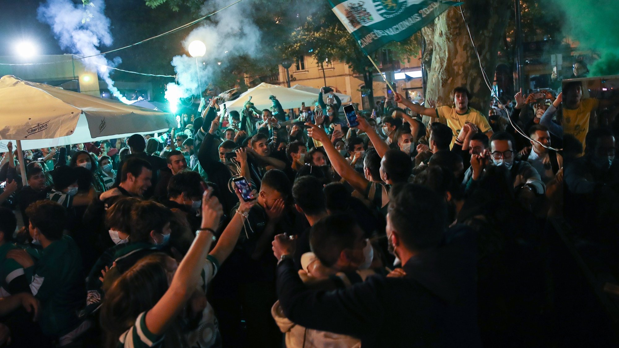 epa09192604 Sporting supporters celebrate the First League Soccer title at Republica square, in Coimbra, Portugal, 11 May 2021. Sporting of Lisbon defeated Boavista in their Portuguese First League soccer match conquering the First League trophy of the season 2020/2021, a trophy the team has been chasing since the season 2001/2002.  EPA/PAULO NOVAIS