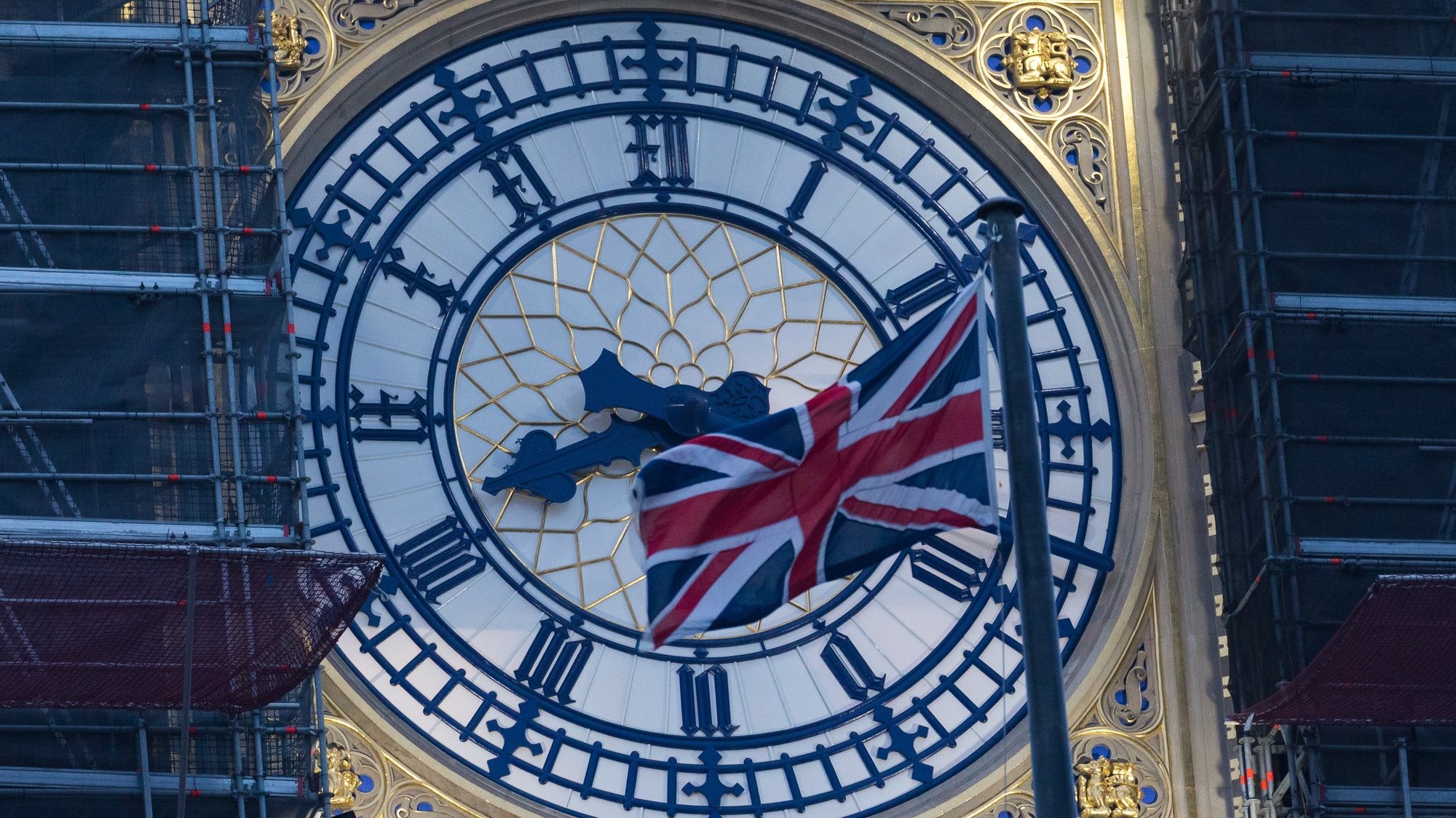 epa08913909 Big Ben clock face with a Union Jack flag seen at dawn in Westminster, London, Britain, 01 January 2021. Britain left the European Union at 11pm on 31 December 2020.  EPA/VICKIE FLORES