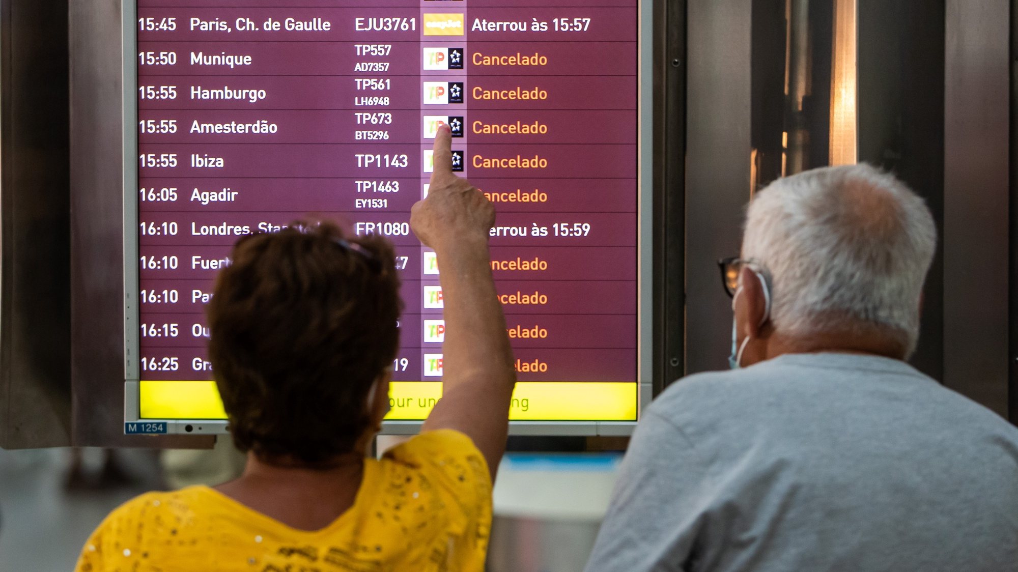 A woman points to a monitor with incoming flights to Lisbon, many of them canceled due to a strike of the handling company, Groundforce, which is causing major disruption in the Lisbon Airport, causing the cancelation of dozens of flights, in Lisbon, Portugal, 17 July 2021. Groundforce workers are protesting against colective dismissal of workers and low salaries. JOSE SENA GOULAO/LUSA