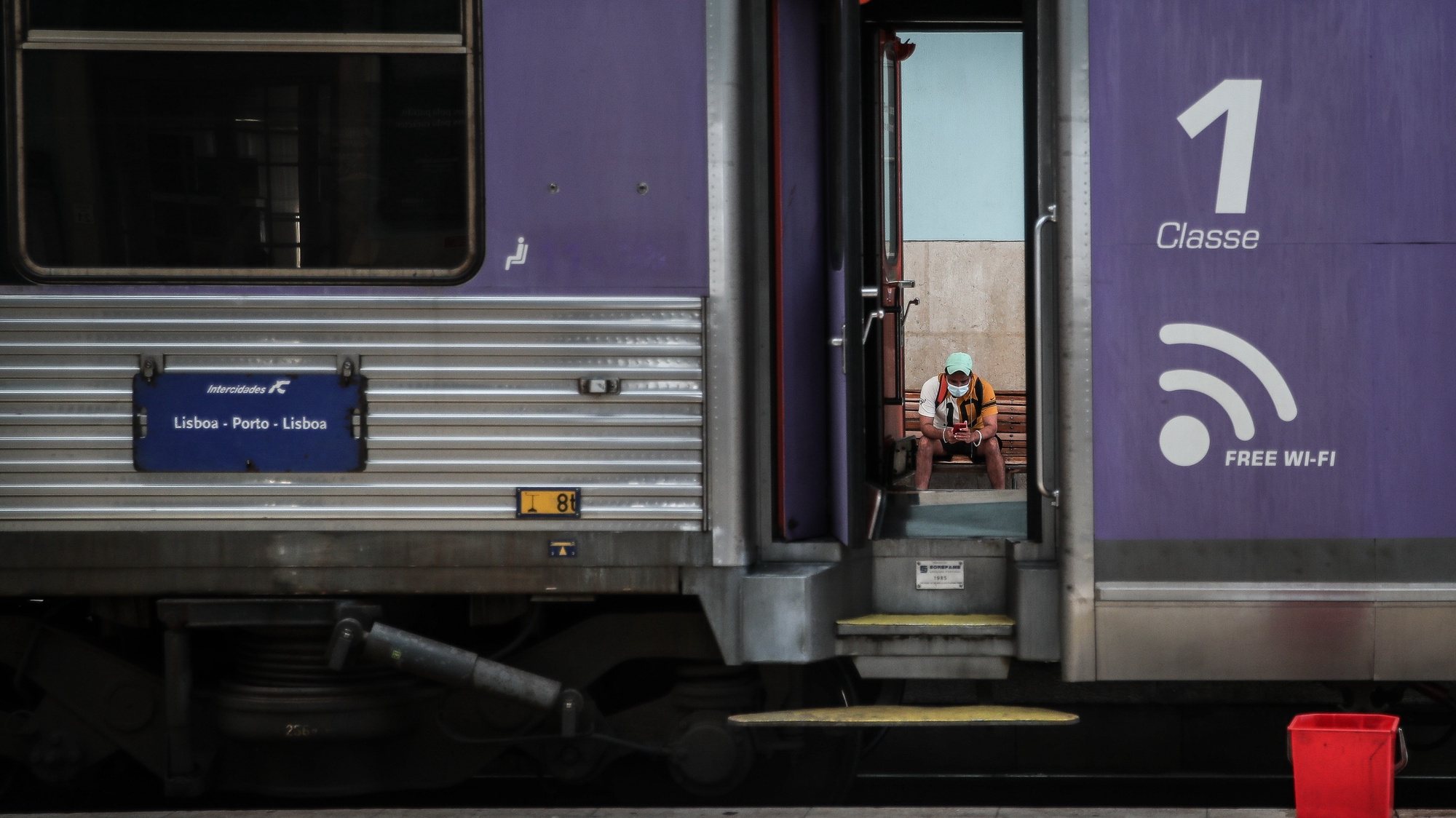 Um utente espera junto a um comboio parado na Estação de Santa Apolónia