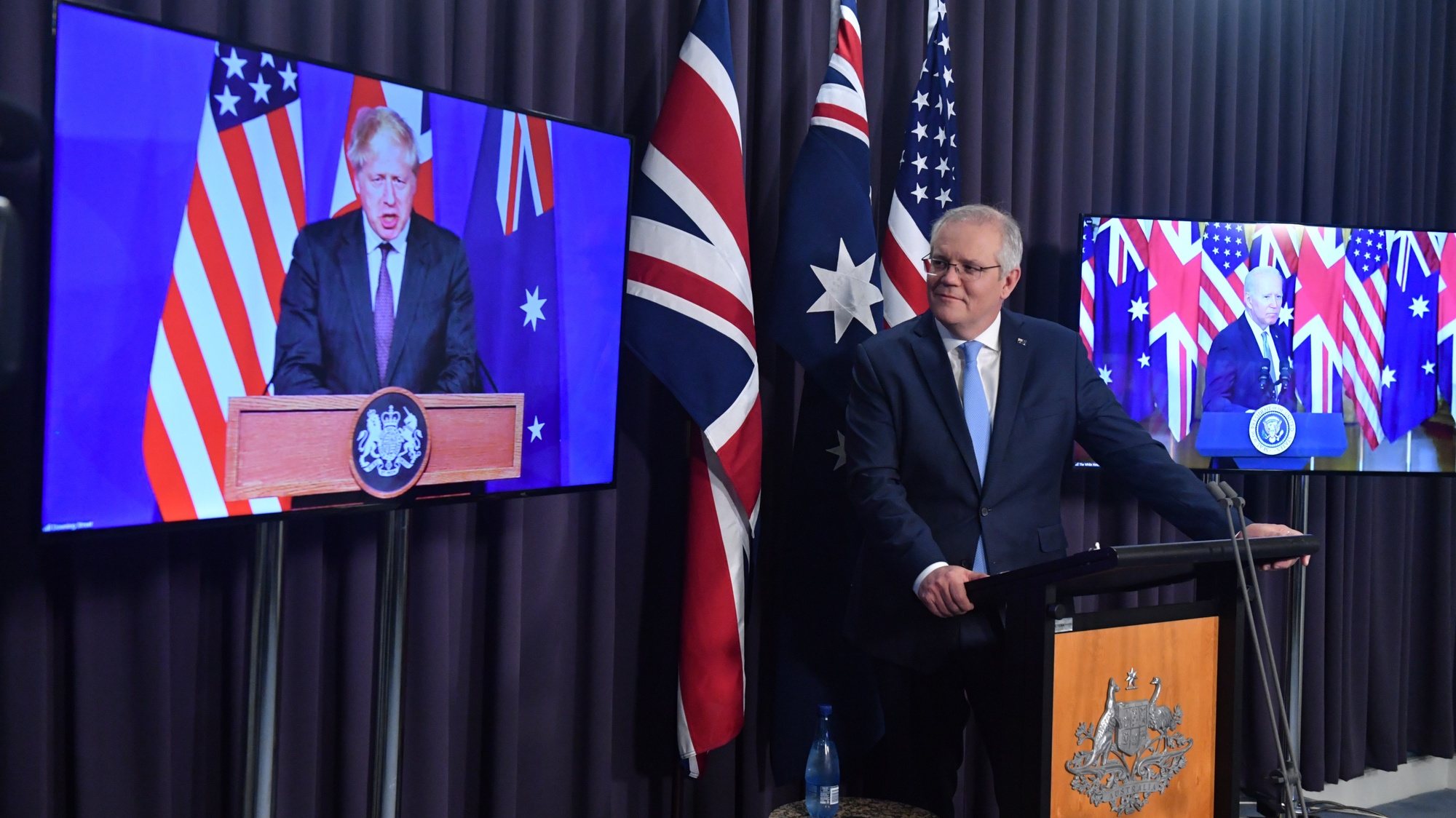 epa09470855 Britain&#039;s Prime Minister Boris Johnson, Australia&#039;s Prime Minister Scott Morrison (C) and US President Joe Biden attend a joint press conference via audio visual link (AVL) from The Blue Room at Parliament House in Canberra, Australian Capital Territory, Australia, 16 September 2021. Australia, the United Kingdom and the United States agreed to the creation of a trilateral security partnership to be known as AUKUS.  EPA/MICK TSIKAS AUSTRALIA AND NEW ZEALAND OUT