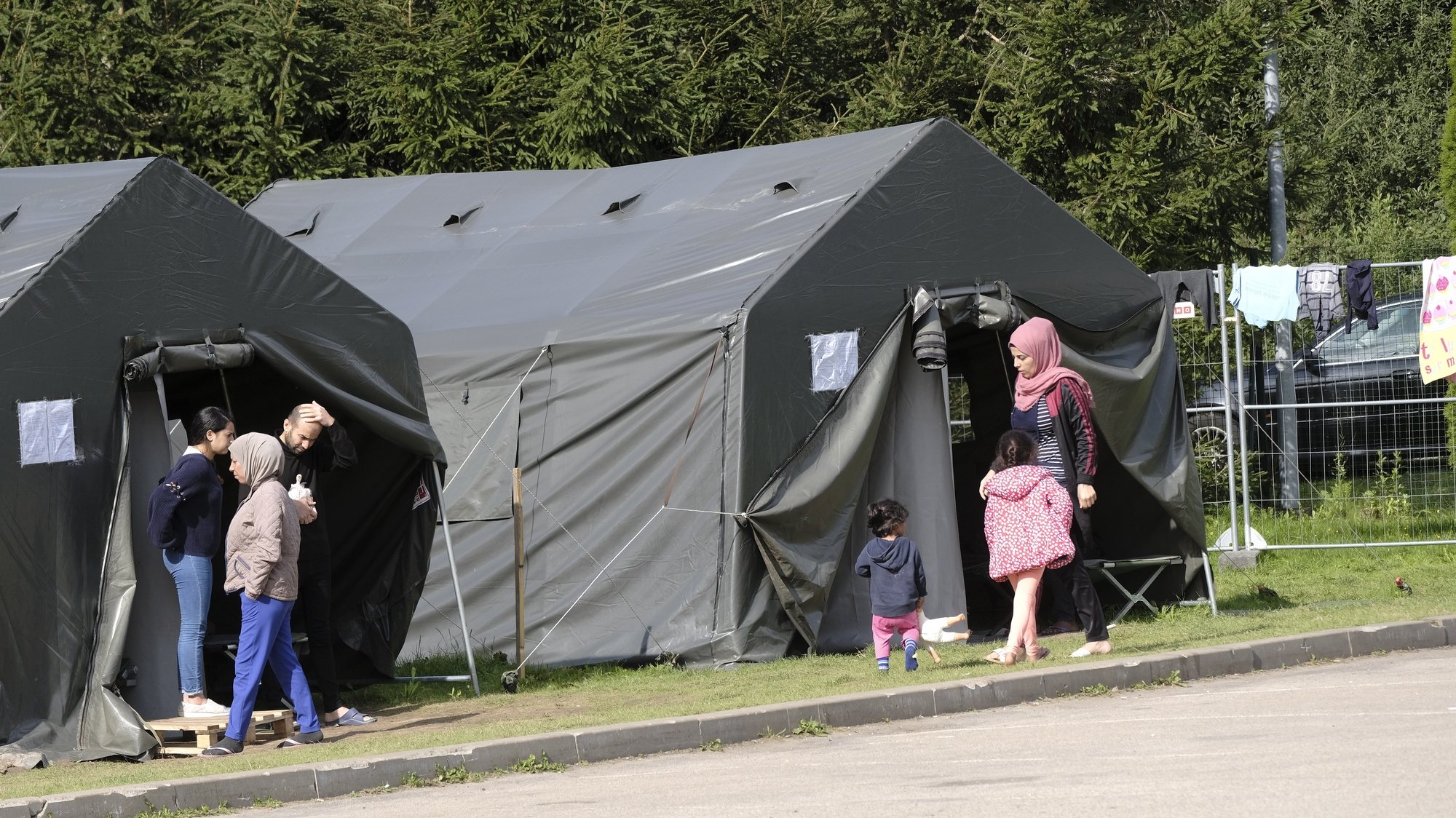 epa09428104 Migrants in the tent camp close to the Lithuania - Belarus border near Medininkai, Lithuania, 24 August 2021. More than 4,000 migrants have entered Lithuania illegally from neighbouring Belarus so far this year.  EPA/VALDA KALNINA