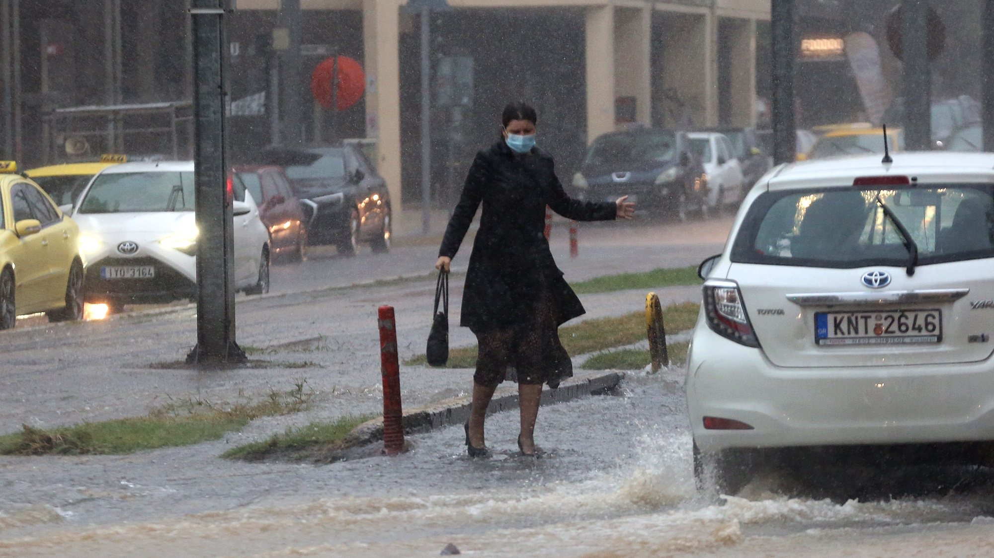 epa09523317 A woman makes her way under heavy rain in Athens, Greece, 14 October 2021. An emergency warning was sent to Attica residents from the 112 Emergency Communications Service on 14 October warning them of dangerous weather conditions and to avoid all non-essential travel.  EPA/ORESTIS PANAGIOTOU