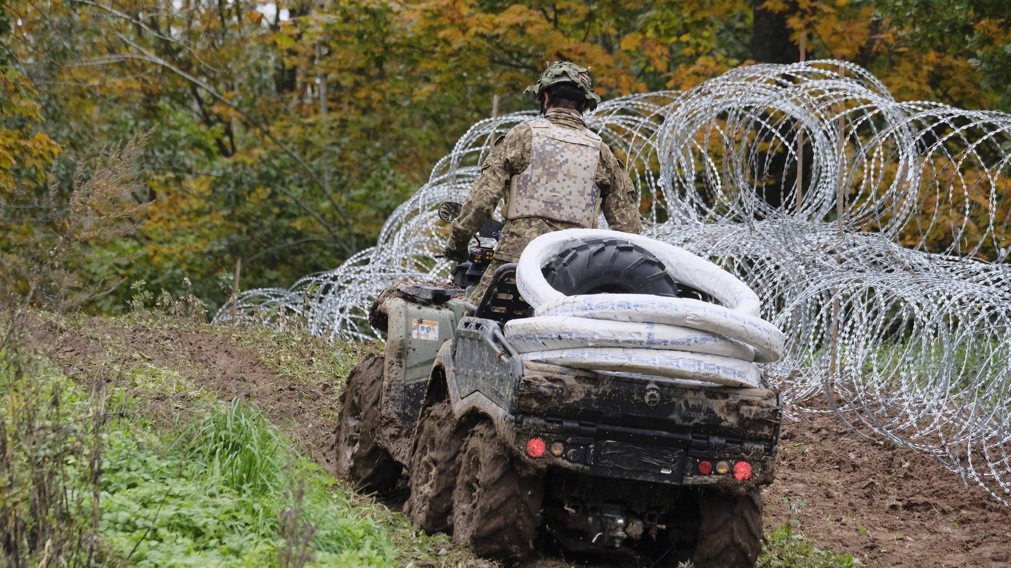 epa09493122 A soldier of Latvian National Armed Forces (NAF) patrols along a new barbed wire fence, donated by the Slovenian Ministry of Defense, on the state border with Belarus in Kraslava region, Latvia, 28 September 2021. This fence will cover the most critical border areas. Since August 10, a total of about 850 people have been reportedly deterred from crossing the state border illegally. According to the officials of Latvia, Lithuania and Poland, the pressure of migrants on the border is organized by Belarus.  EPA/VALDA KALNINA