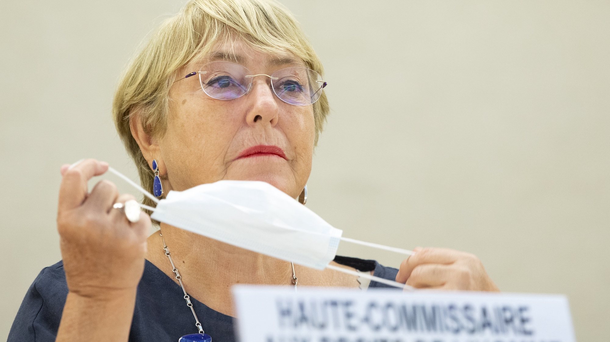 epa09465123 UN High Commissioner for Human Rights, Chilean Michelle Bachelet, removes her protective face mask prior her statement, during the 48th session of the Human Rights Council, at the European headquarters of the United Nation, in Geneva, Switzerland, 13 September 2021.  EPA/SALVATORE DI NOLFI