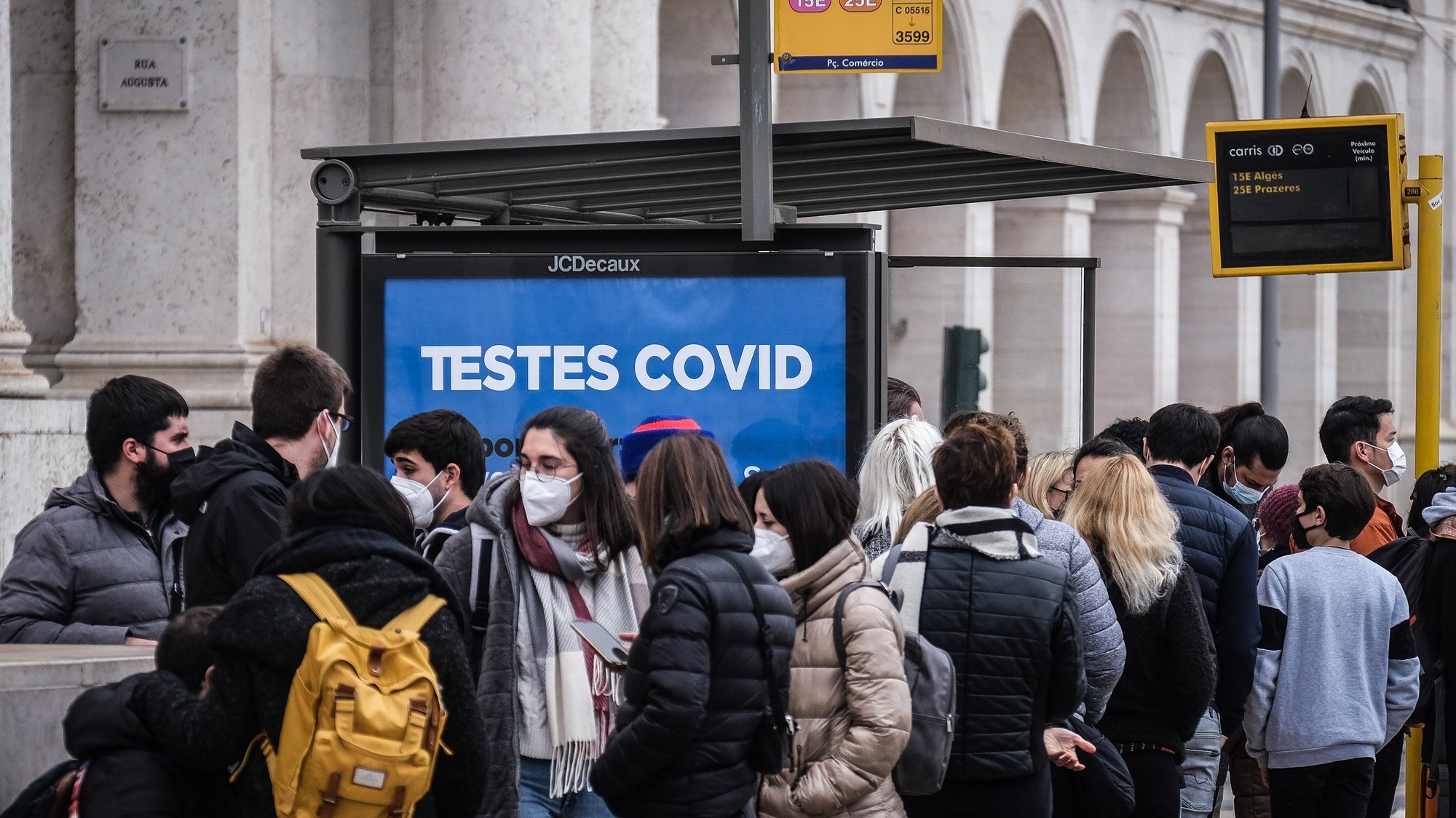 People waiting for a bus next to a sign advertising covid testing in Lisbon, Portugal, 30 December 2021. Yesterday, Portugal registered 26,867 new covid-19 infections, a new high since the start of the pandemic. Due to the surge of positive cases and the rise of the Omicron variant Portugal&#039;s government decided to implement restrictive measures such as closing schools, bars and clubs. MARIO CRUZ/LUSA