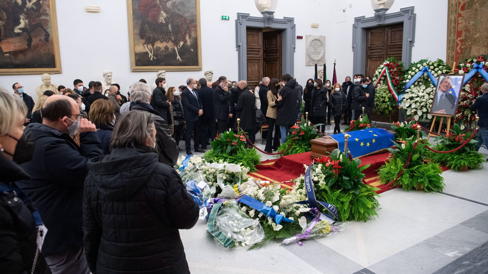 O caixão de David Sassoli coberto com uma bandeira da UE enquanto as pessoas prestam uma última homenagem