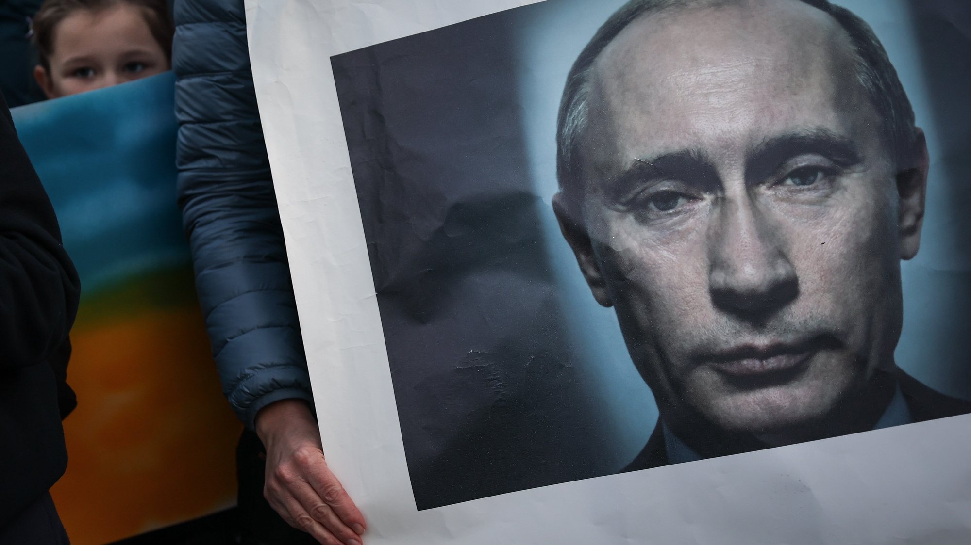 Uma manifestante seguram um retrato de Vladimir Putin durante um Cordão Humano pela Paz na Ucrânia que fez um percurso do Restelo até Belém, Lisboa, 26 de fevereiro de 2022. RODRIGO ANTUNES/LUSA