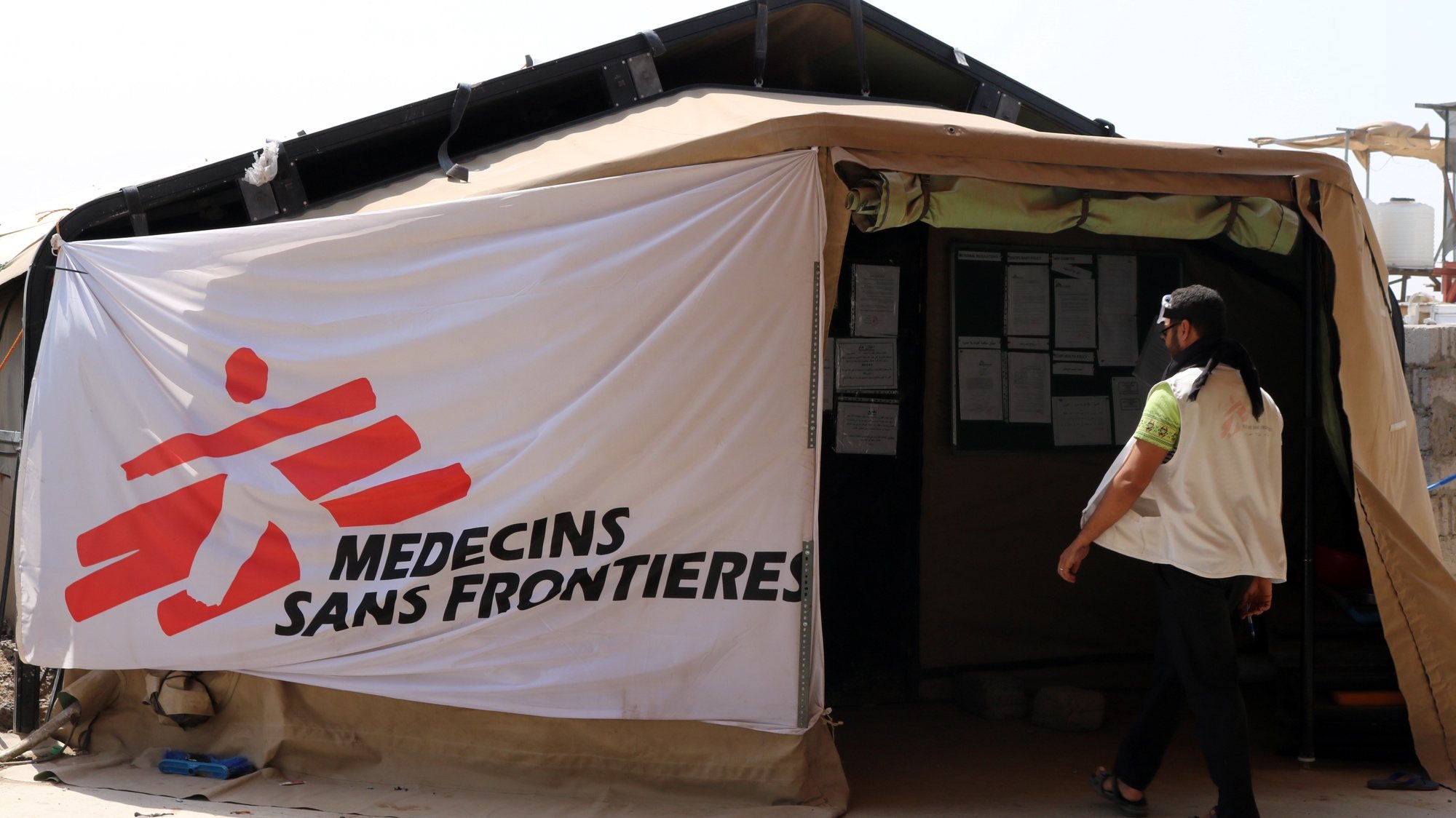 epa07986289 A staff of Doctors Without Borders (MSF) enters an alternative emergency tent after a MSF-run hospital was partially destroyed during an airstrike in the southwestern city of Mocha, Yemen, 10 November 2019.  According to reports, a hospital managed by Doctors Without Borders (MSF) in the Yemeni city of Mocha was partially destroyed four days ago during an airstrike that hit surrounding buildings, including a military warehouse. No casualties were reported.  EPA/NAJEEB ALMAHBOOBI