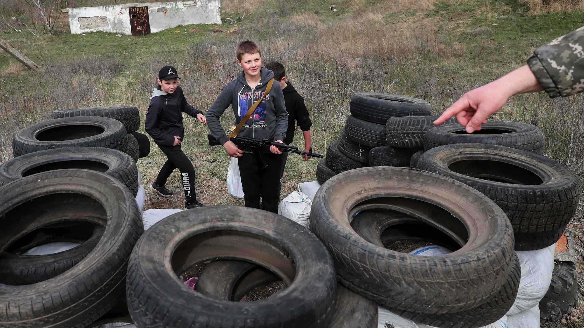 An unidentified territorial defence member talks to Ivan, 14 years (R), who borrowed his unloaded kalasnikov, Maxin, 14 (R)  and Dennis, 13,  in a fake checkpoint they made in the neighborhood in Ovidiopol. They asks for a password and passports just for fun. In the future they want to be soldiers to defend the country, Odessa, 01 April 2022. On 24 February Russian troops had entered Ukrainian territory in what the Russian president declared a &#039;special military operation&#039;, resulting in fighting and destruction in the country, a huge flow of refugees, and multiple sanctions against Russia. NUNO VEIGA/LUSA