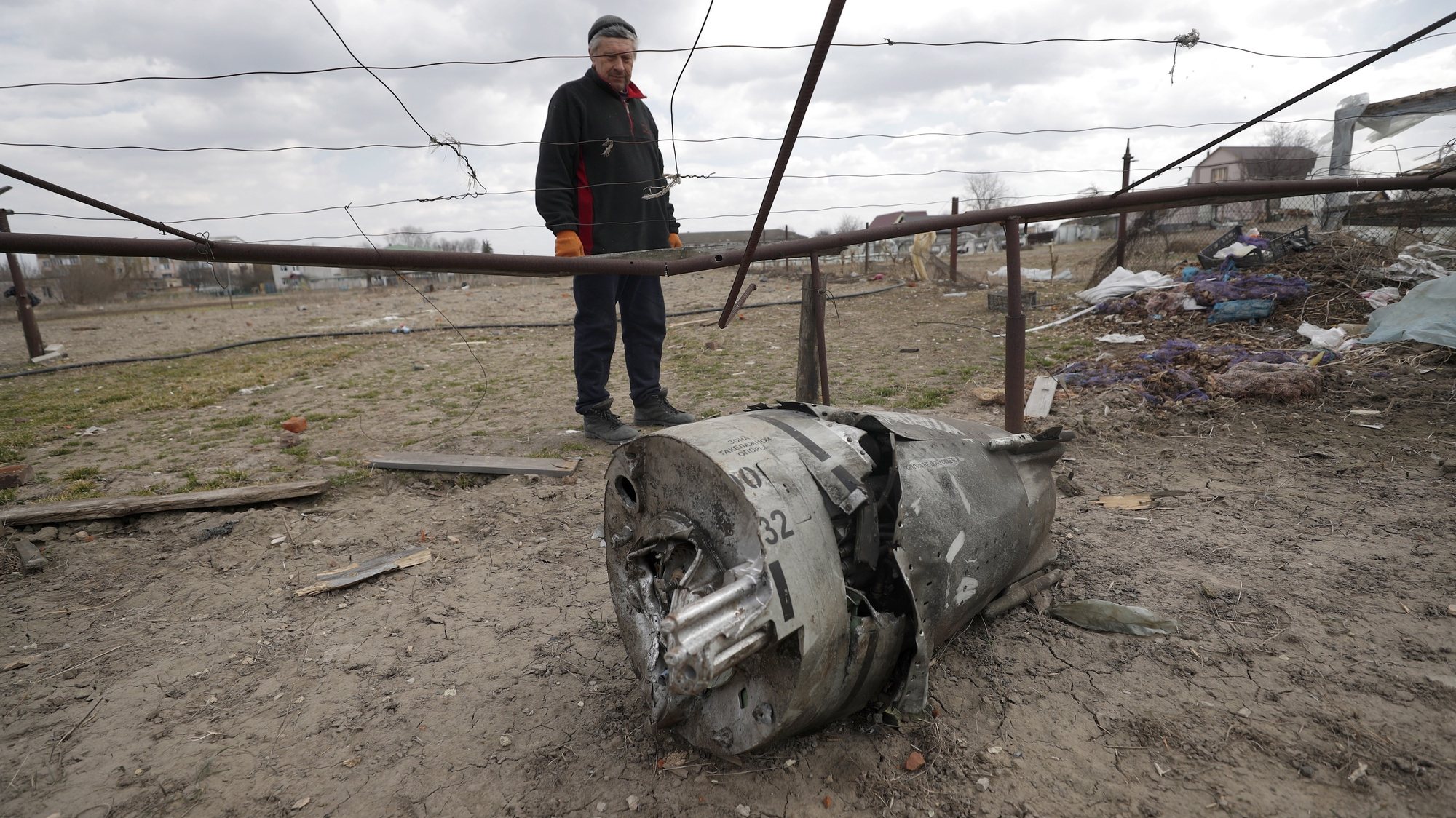 epa09857824 Ditchinku Nikulayf, 64, inspects the wreckage of a missile&#039;s engine in the aftermath of a Russian airstrike in the village of Ulica Szkolna, Kyiv Oblast, 29 March 2022. Russian troops entered Ukraine on 24 February resulting in fighting and destruction in the country, and triggering a series of severe economic sanctions on Russia.  EPA/ATEF SAFADI