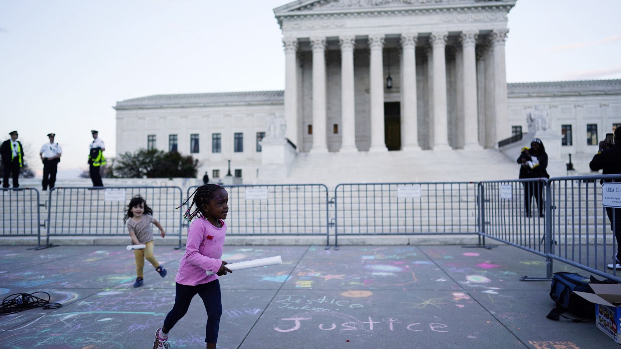 epa09879610 A young child plays as people celebrate the historic Senate confirmation of Judge Ketanji Brown Jackson to be an Associate Justice of the US Supreme Court at a rally outside the Supreme Court, in Washington DC, USA, 08 April 2022.  EPA/WILL OLIVER